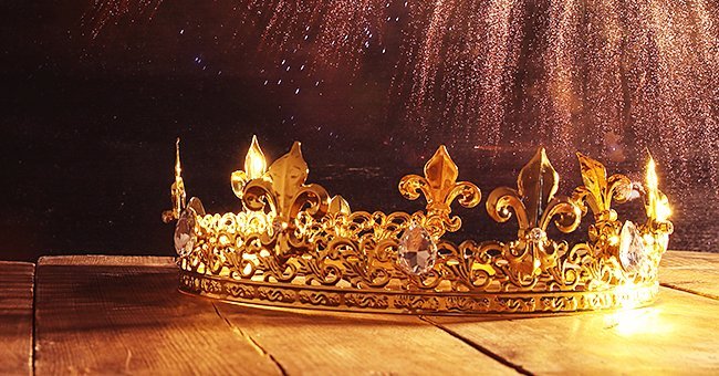Photo of a golden crown placed on a wooden surface | Source: Shutterstock