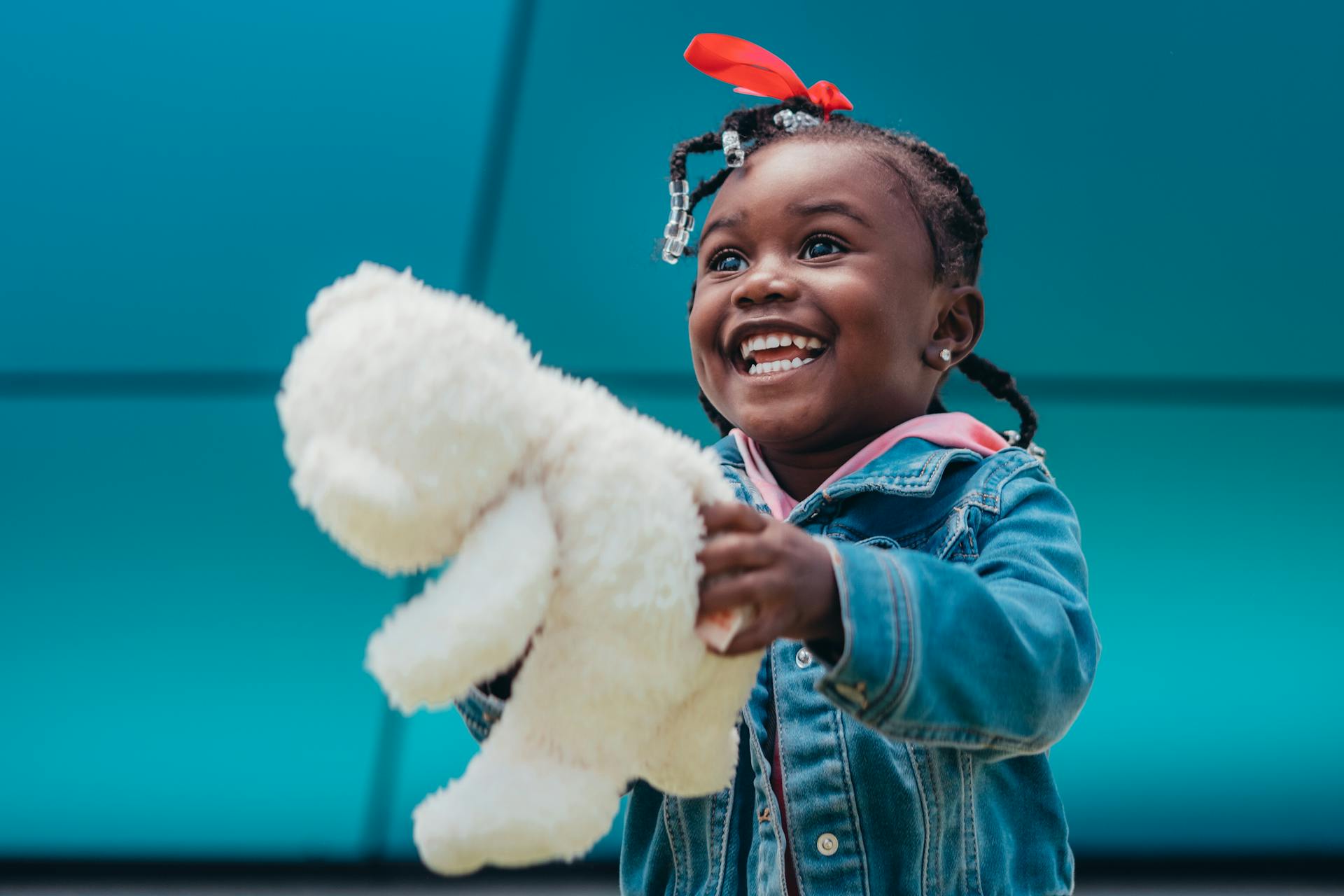 Niña feliz sosteniendo un peluche | Fuente: Pexels