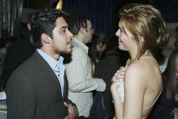 Actors Wilmer Valderrama and Mandy Moore talk at the after-party for United Artists' "Saved" at the Beverly Hills Community Sports Center on May 13, 2004, in Beverly Hills, California. | Source: Getty Images.