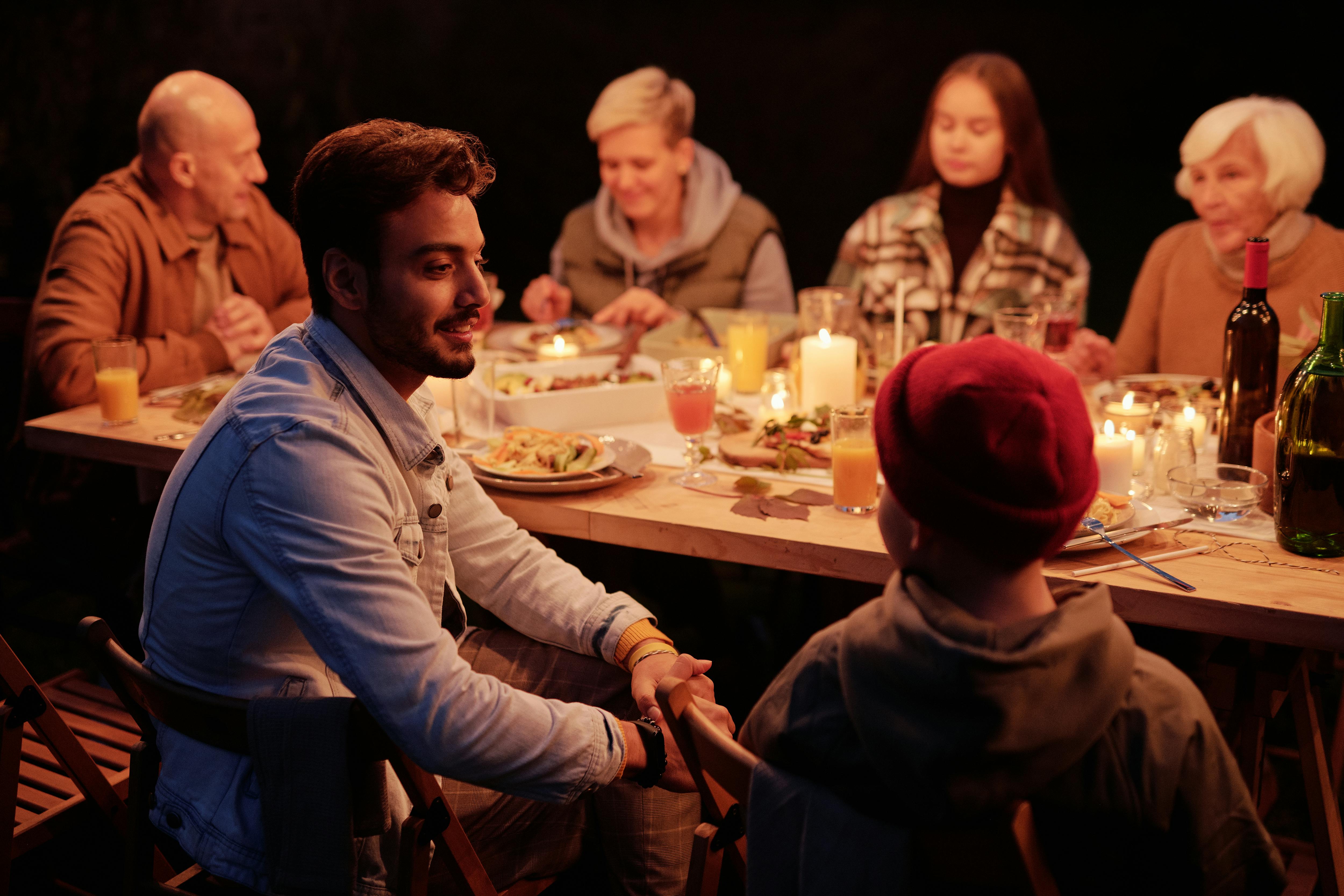 People gathering at dinner in night garden and chatting | Source: Pexels
