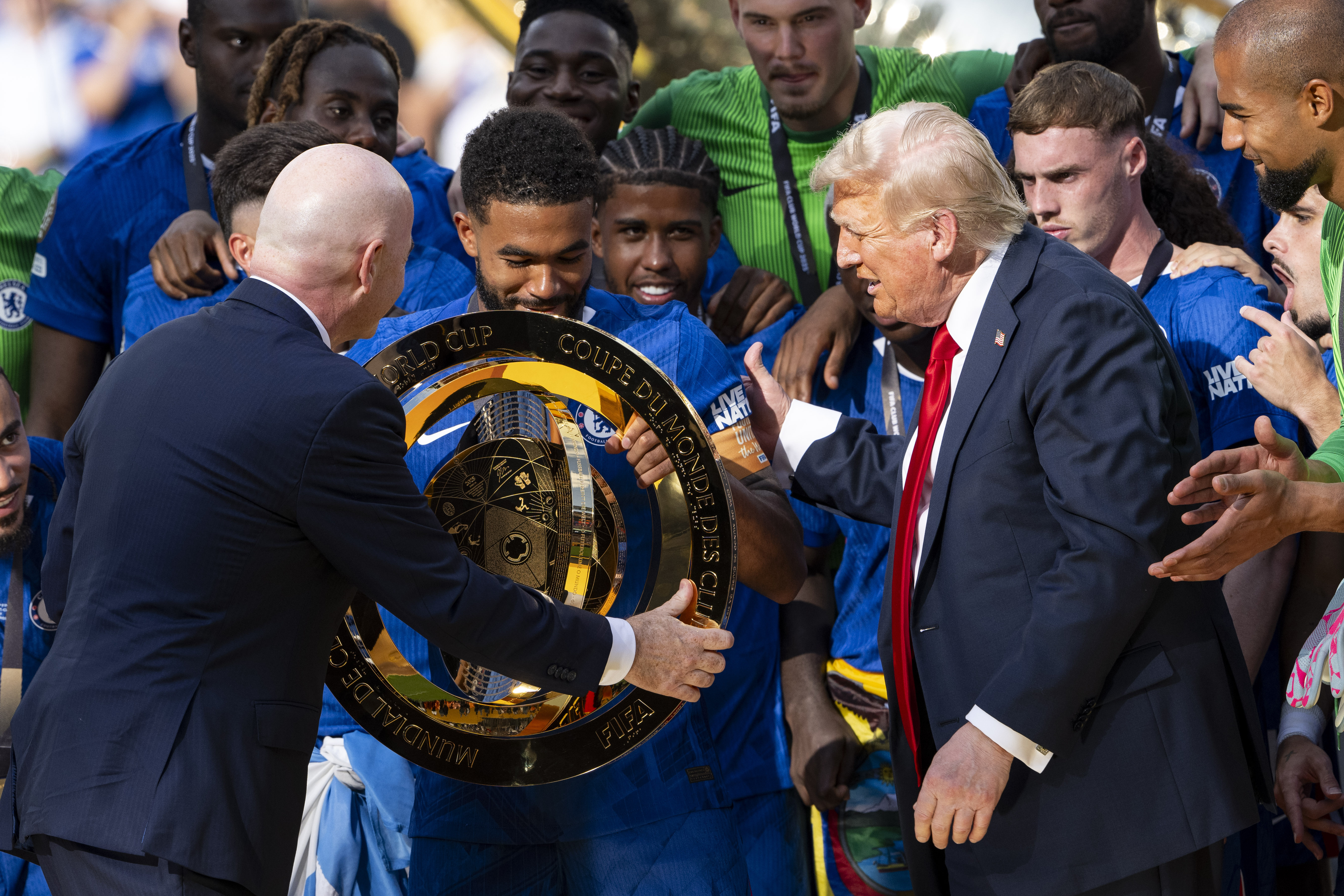 Gianni Infantino and Donald Trump presenting the FIFA Club World Cup trophy to the Chelsea FC players following the FIFA Club World Cup 2025 final on July 13. | Source: Getty Images