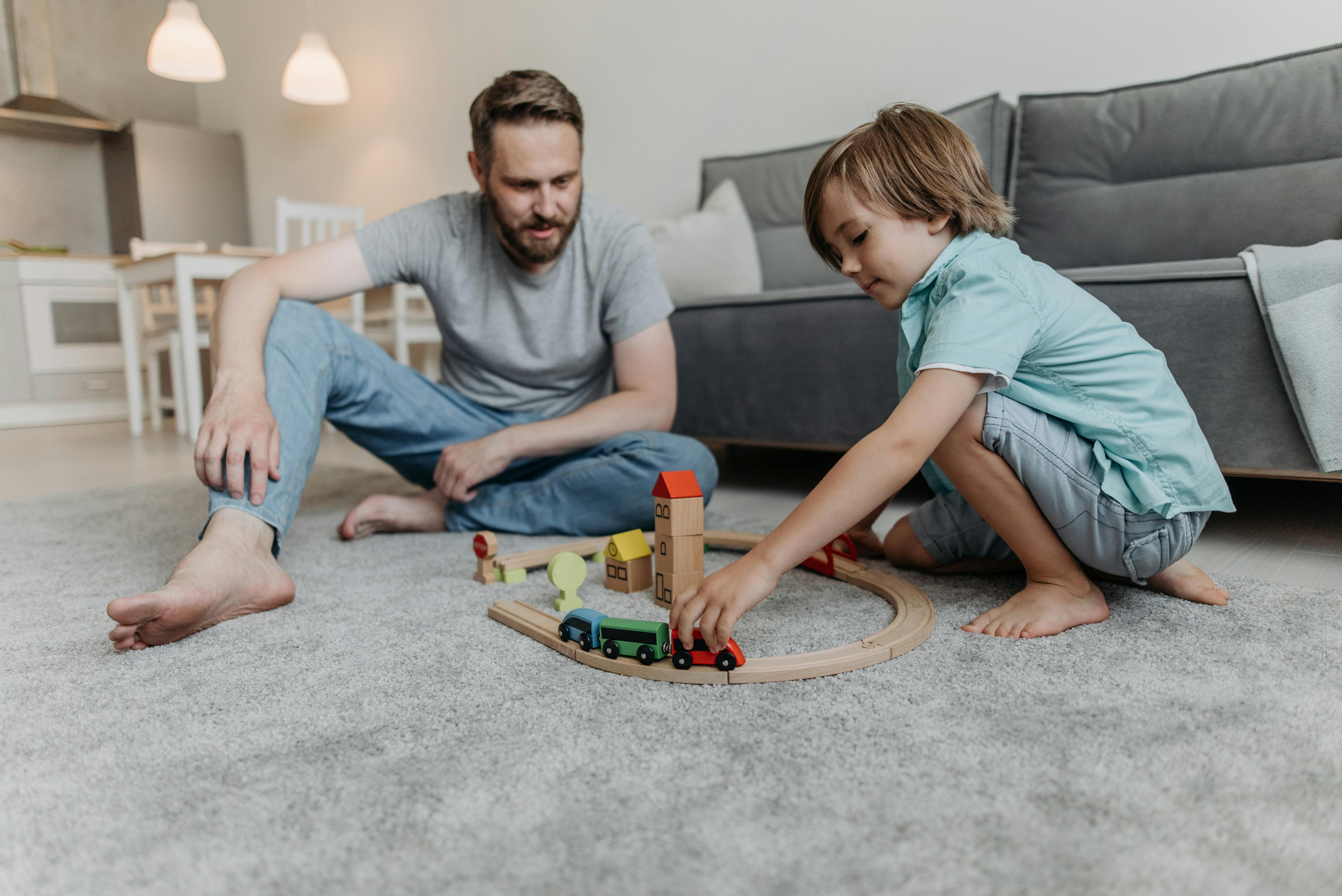 A father playing with his son on the living room floor | Source: Pexels