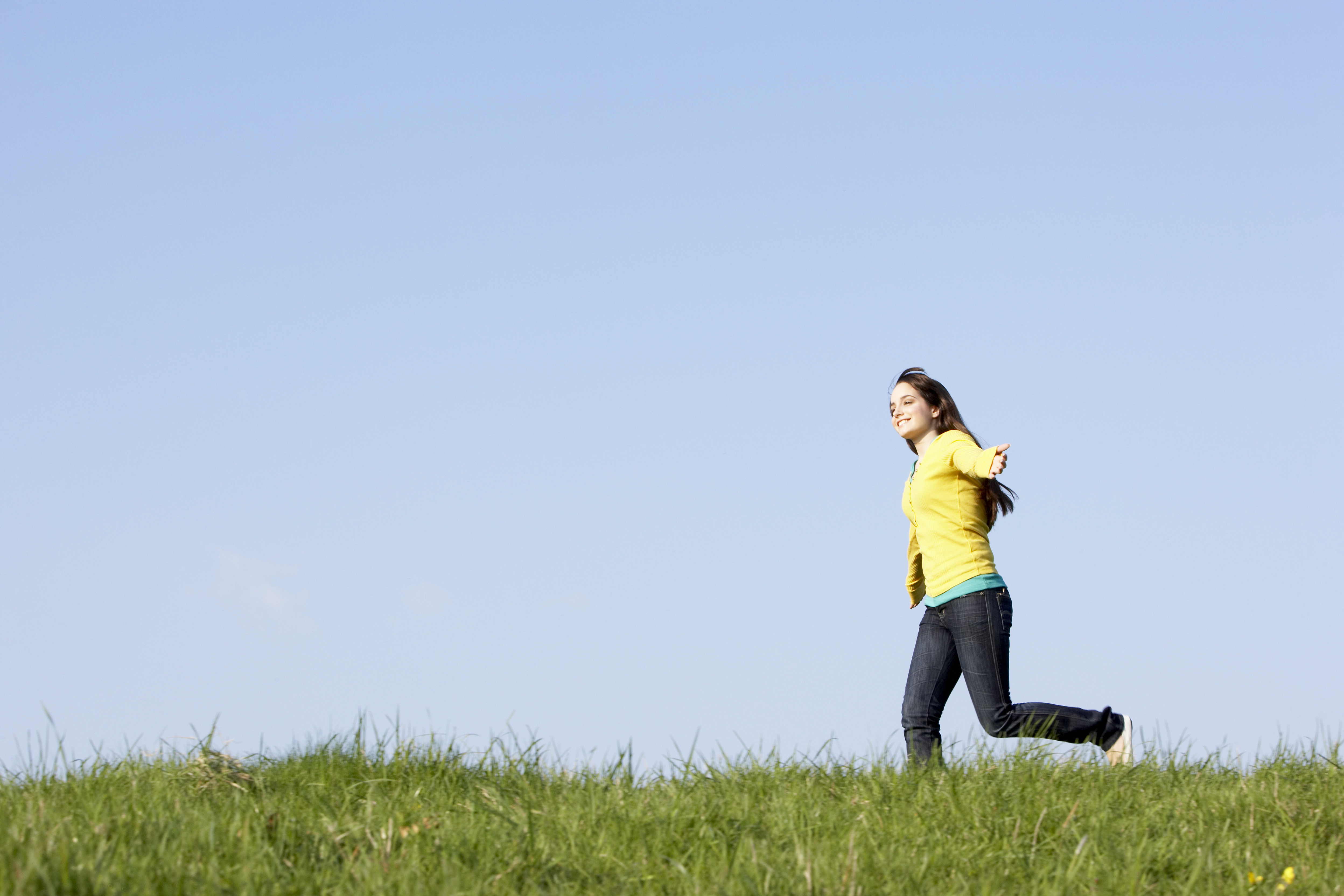 Teenage girl running through summer meadow | Source: Shutterstock.com
