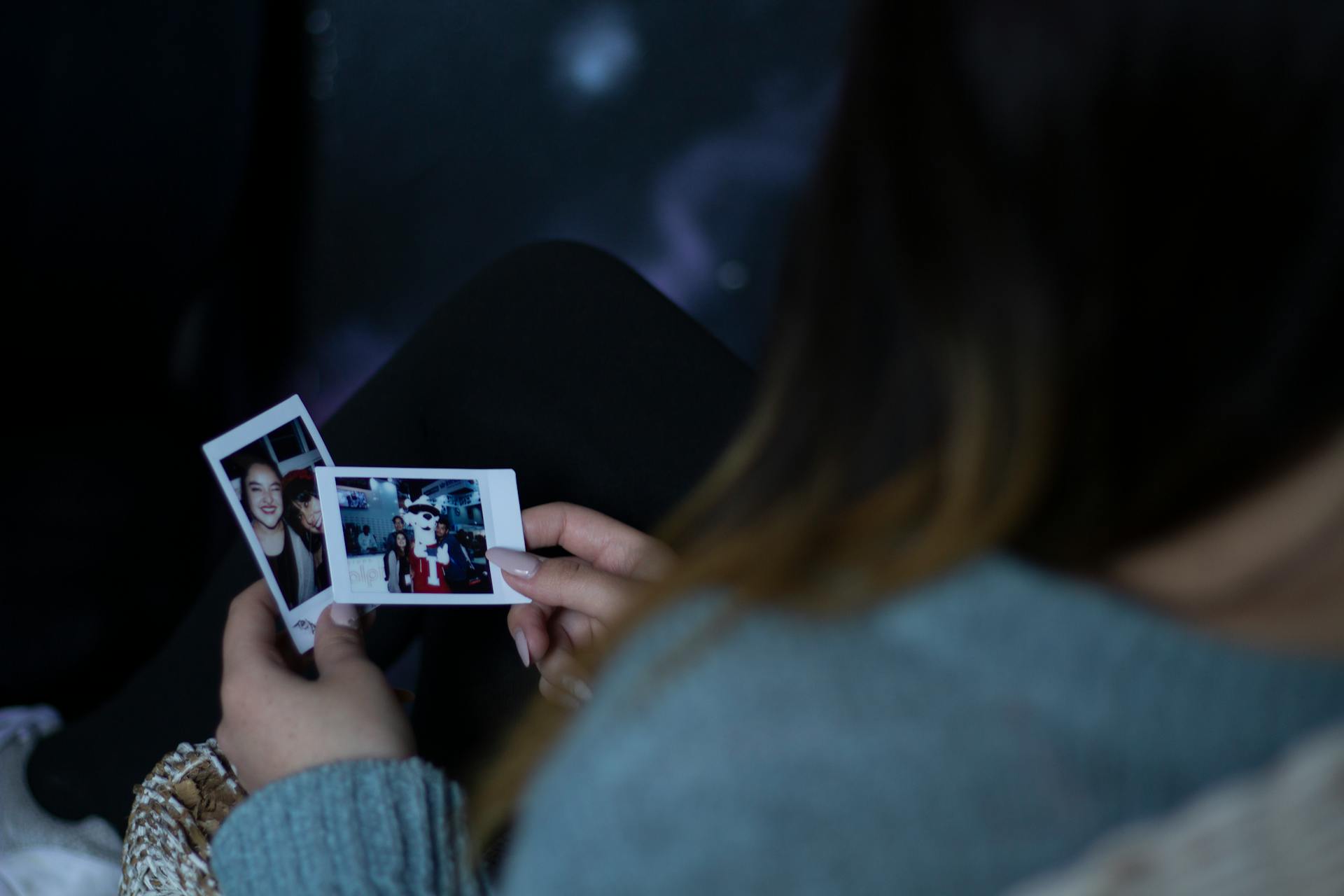 A woman holding two photos | Source: Pexels