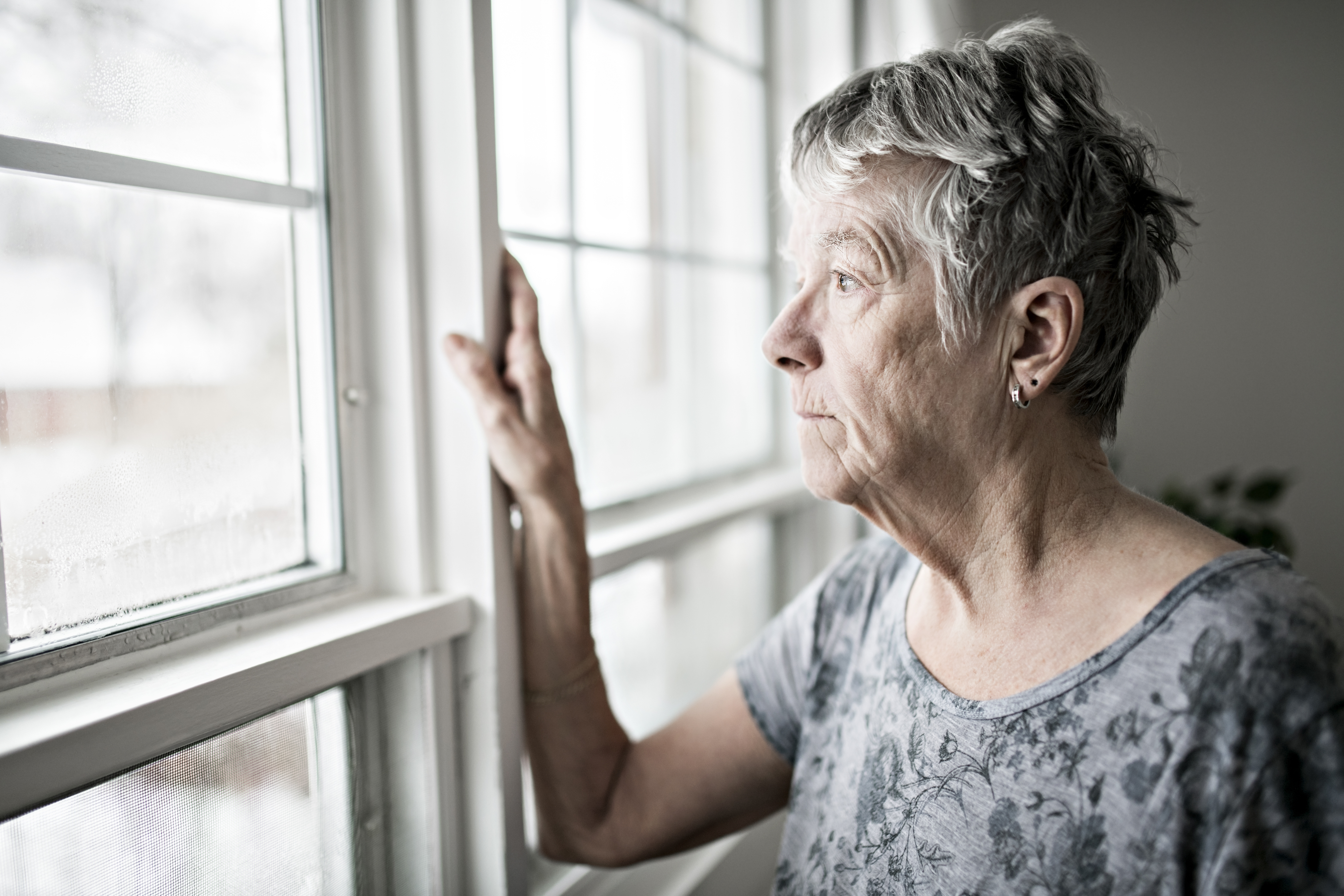 Upset senior woman staring out a window | Source: Getty Images
