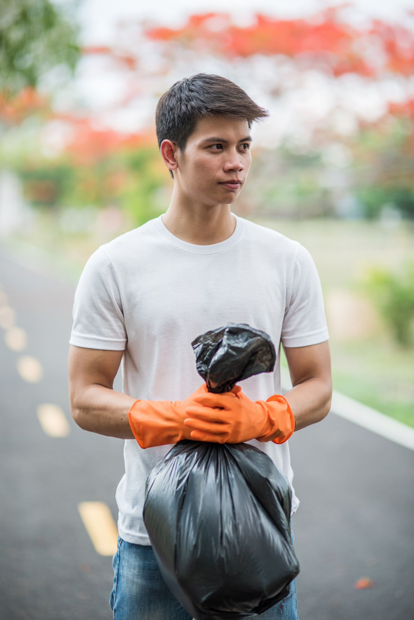 A man outside holding a trash bag | Source: Freepik