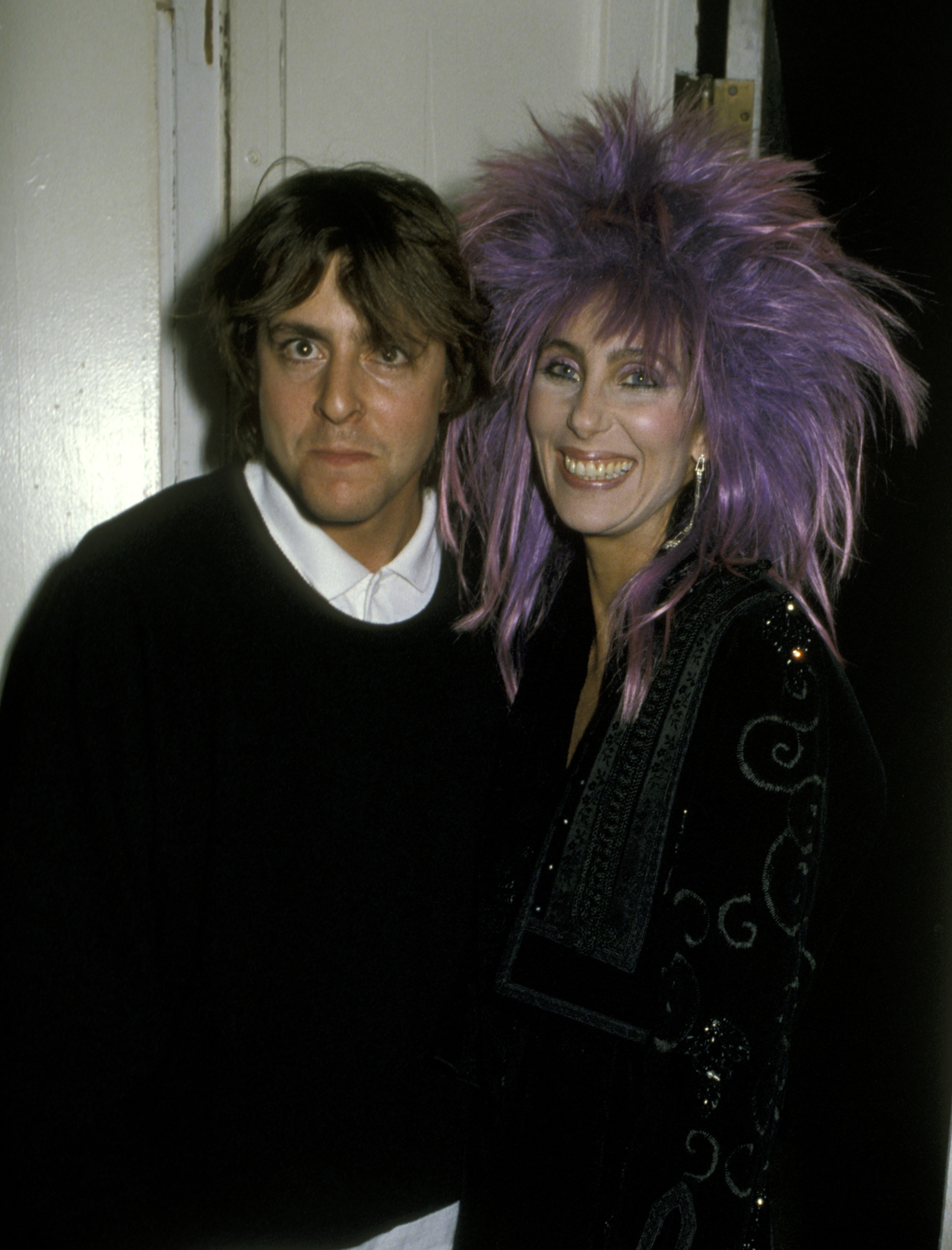 Making a memorable red carpet appearance alongside music icon Cher at the 1985 Los Angeles premiere of "White Nights," the rising actor flashed a playful, wide-eyed expression beside the superstar's striking spiky purple hair. | Source: Getty Images