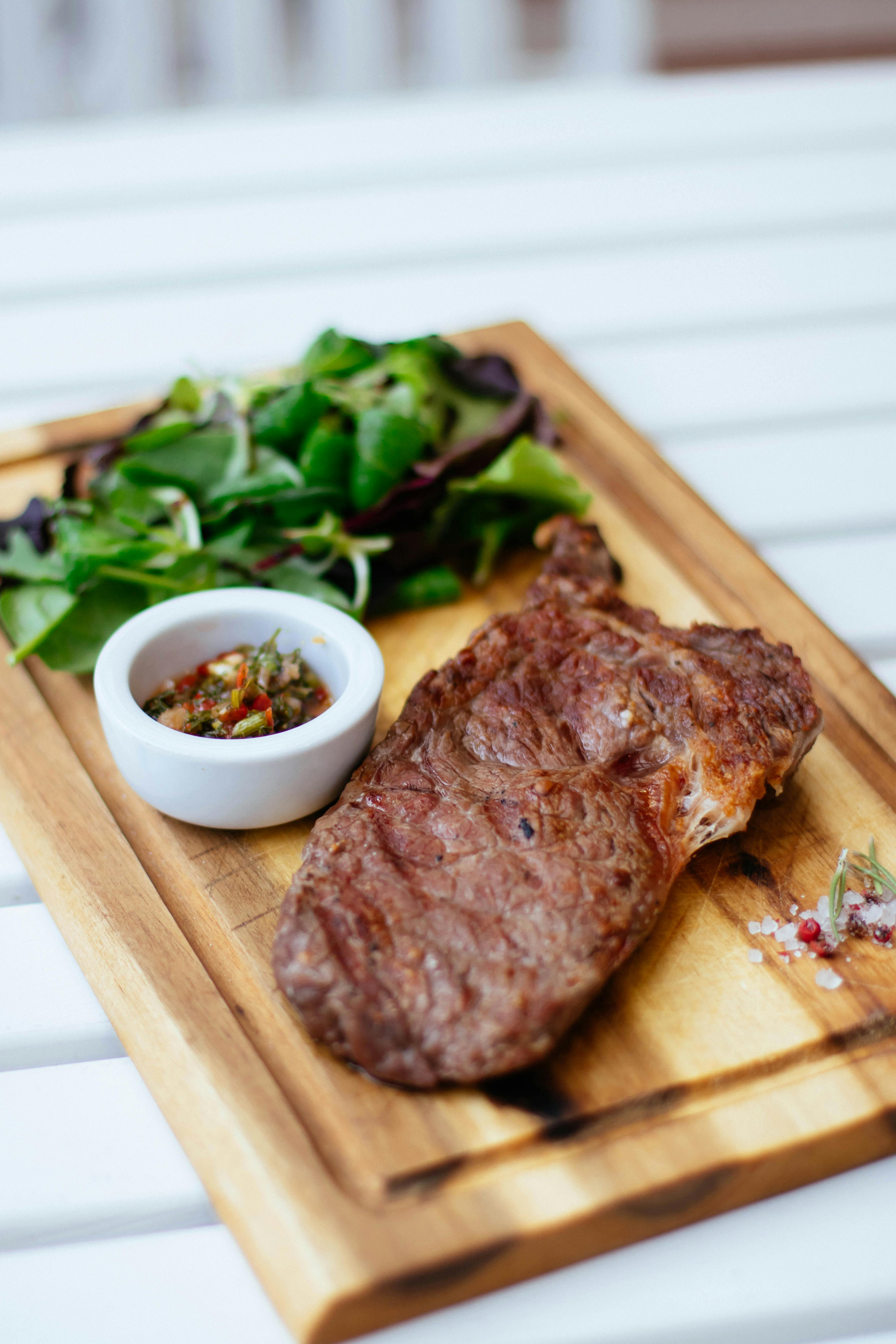 A steak dinner served on a wooden board | Source: Pexels