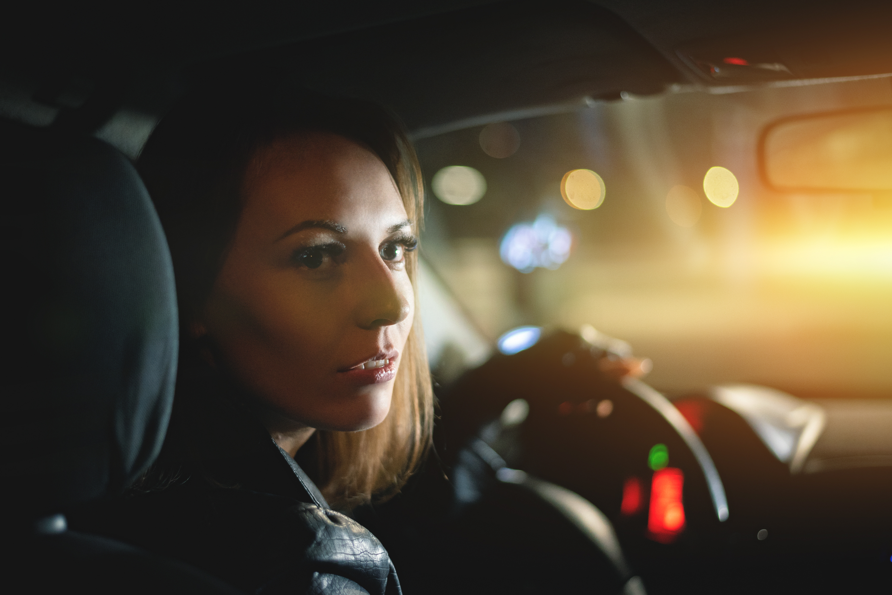 A young woman driver is sitting by steering wheel. | Source: Shutterstock