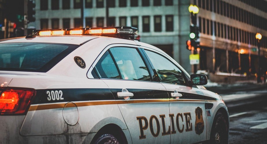 Une voiture de police qui traverse la rue | Photo / Unsplash