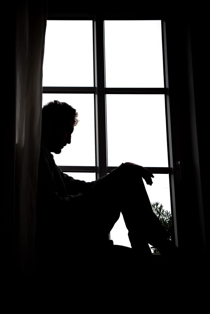 Un homme triste, seul dans le noir. | source : Getty Images
