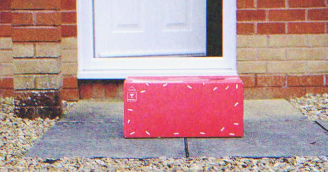 Una caja de regalo en el suelo frente a la entrada de una casa. | Foto: Shutterstock