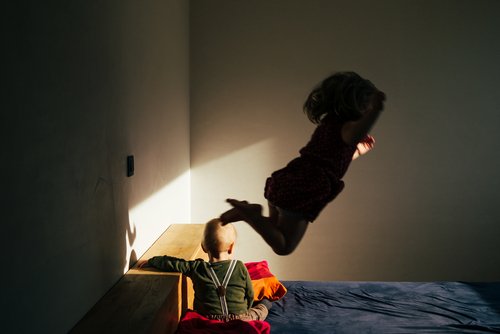 Small children playing on the bed. | Source: Shutterstock