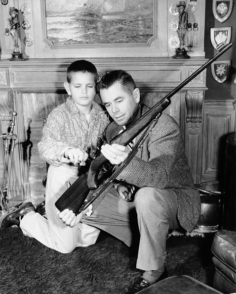 Glenn Ford montrant un fusil a son fils Peter Ford. | Getty images Glenn Ford montrant un fusil a son fils Peter Ford. | Getty images
