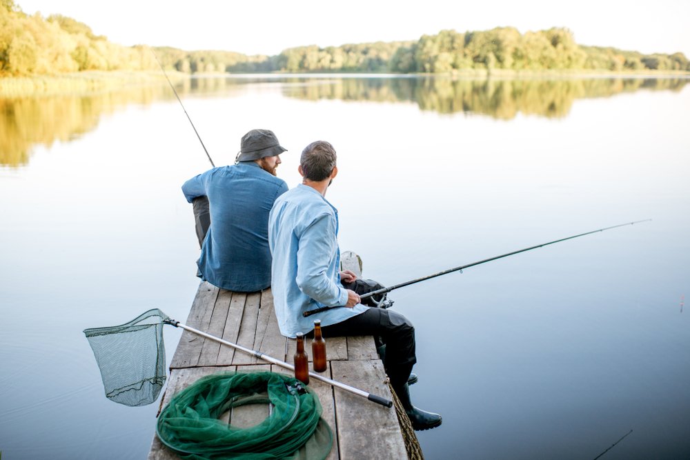A photo of two male friends fishing together. | Photo: Shutterstock.