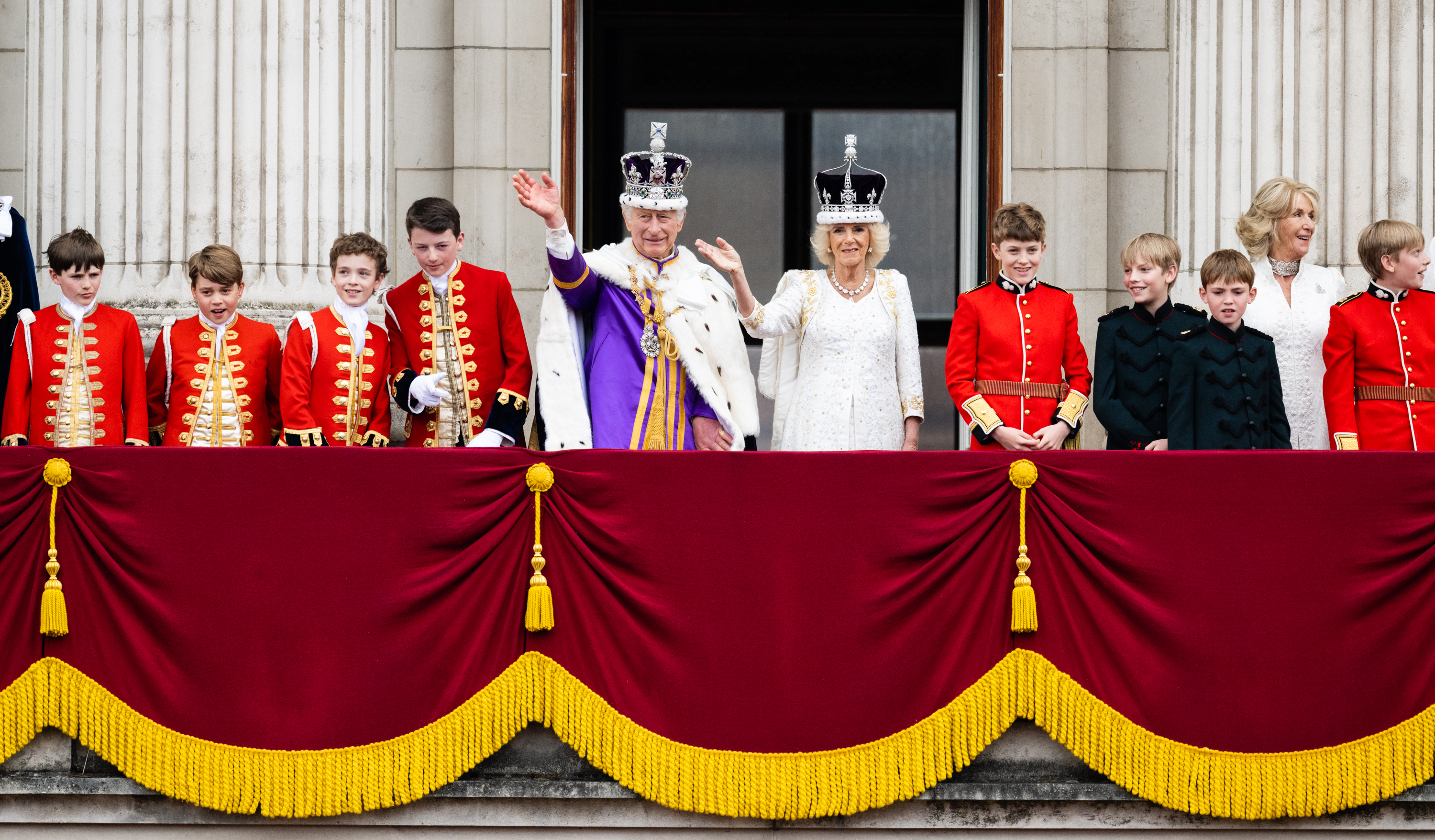 Lord Oliver Cholmondeley, Prince George of Wales, Nicholas Barclay, Ralph Tollemache, King Charles III, Queen Camilla, Freddy Parker Bowles, Louis Lopes, Annabel Elliot, and Gus Lopes at the Buckingham Palace following the Coronation service in London, England, on May 6, 2023. | Source: Getty Images