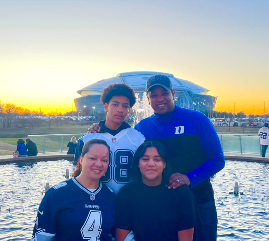Justin and Cerina Fairfax pose with Cameron and Carys near a stadium during an evening outing | Source: Facebook/justin.fairfax.2025