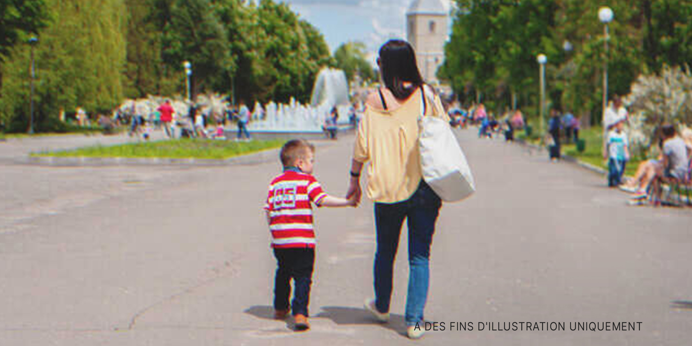 Une femme marchant avec un enfant dans une rue | Source : Shutterstock