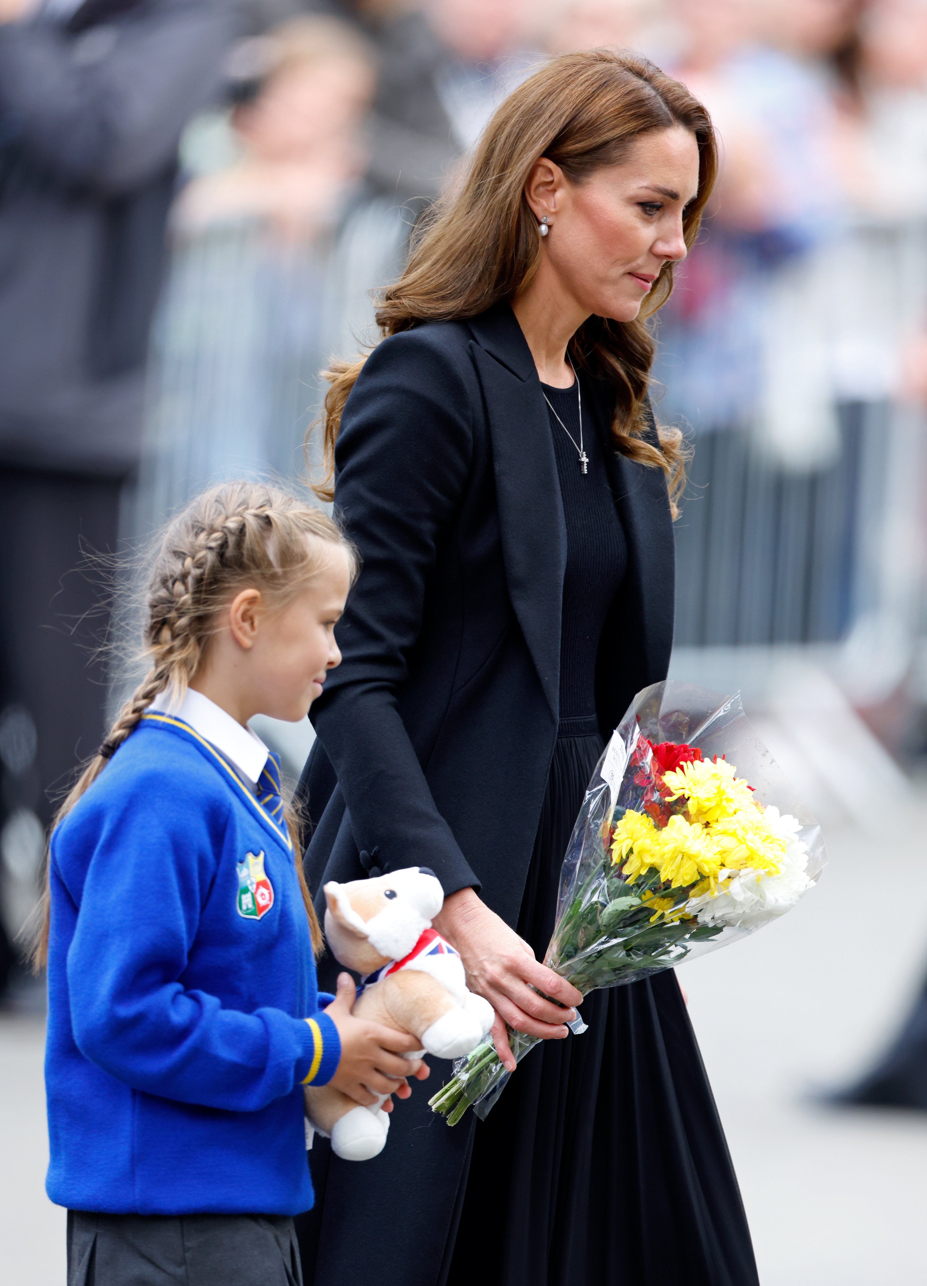 Catherine, Princess of Wales helps a schoolgirl lay her floral tribute at the entrance to Sandringham House, the Norfolk estate of Queen Elizabeth II, on September 15, 2022 in Sandringham, England. | Source: Getty Images