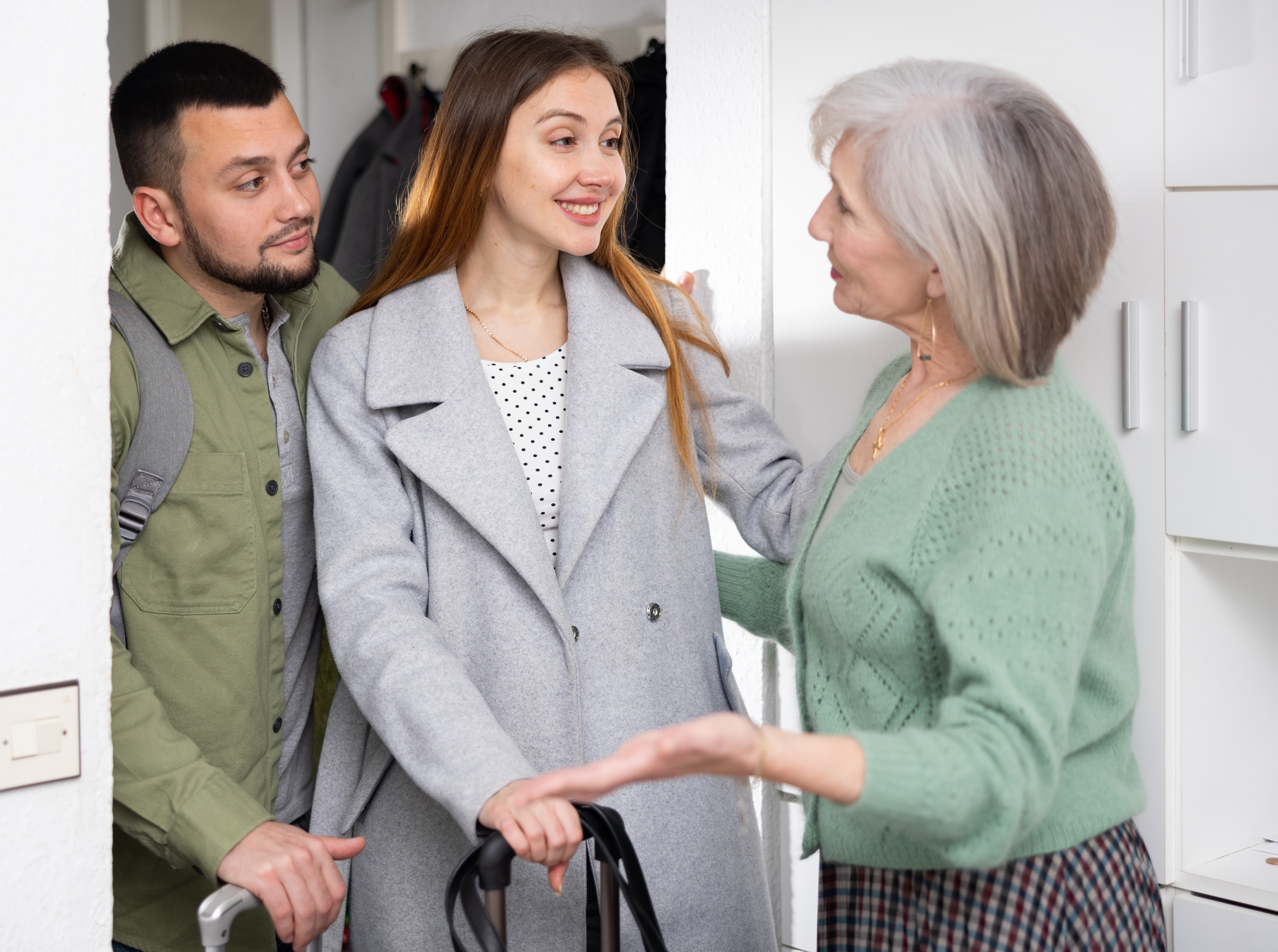 An older woman welcomes her son with his girlfriend | Source: Shutterstock