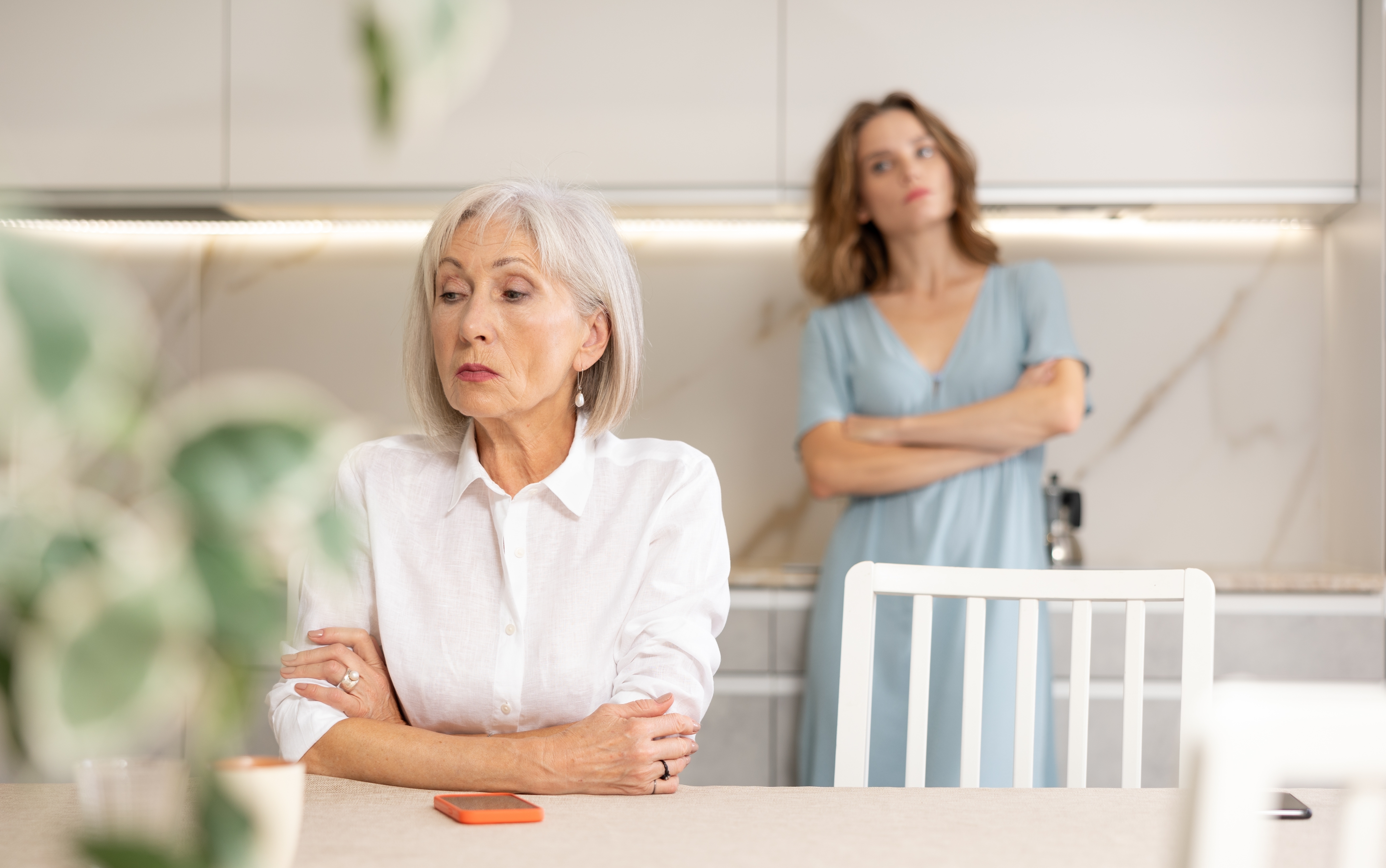 An older woman and a younger woman, their arms folded in anger | Source: Shutterstock