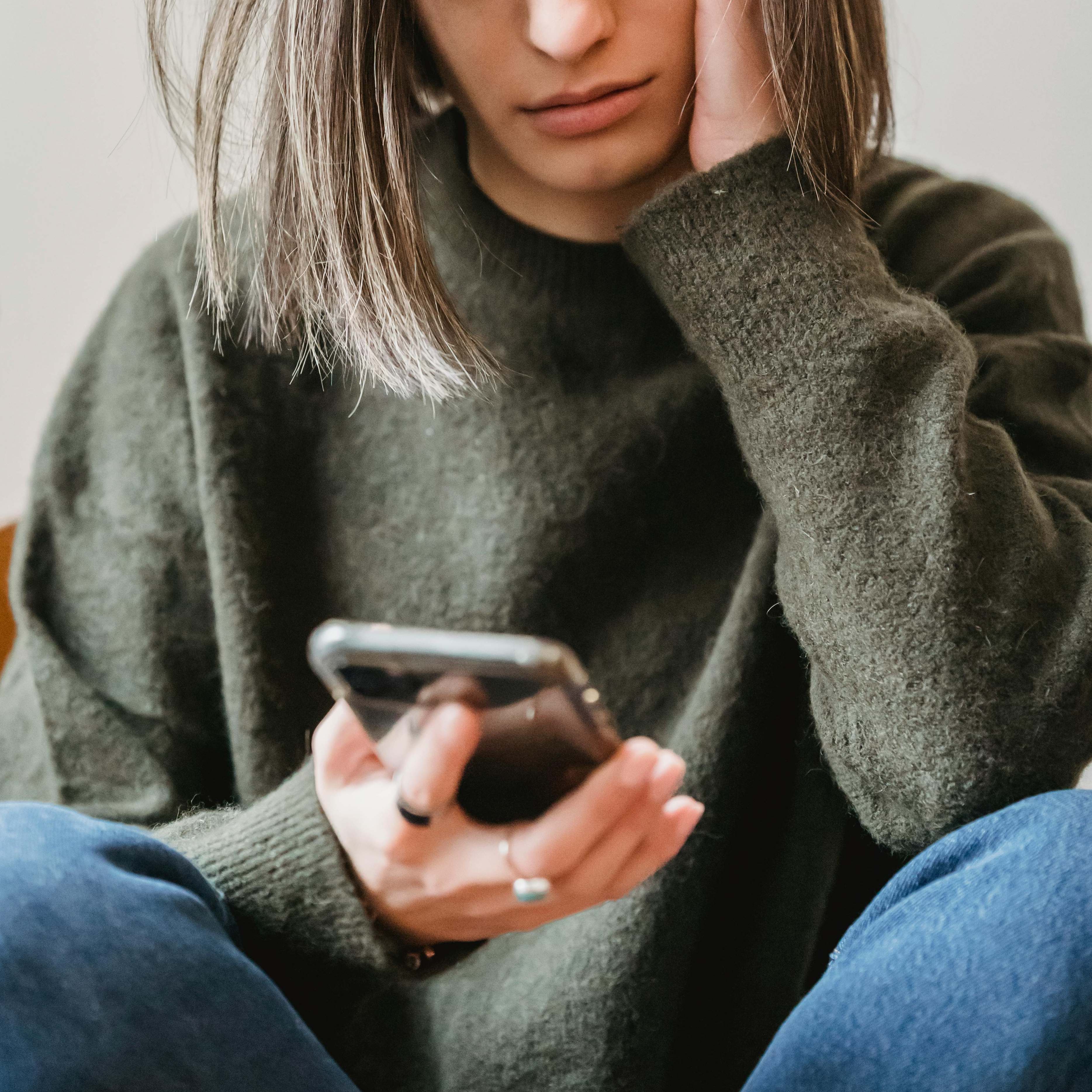 A woman checking her phone anxiously | Source: Pexels