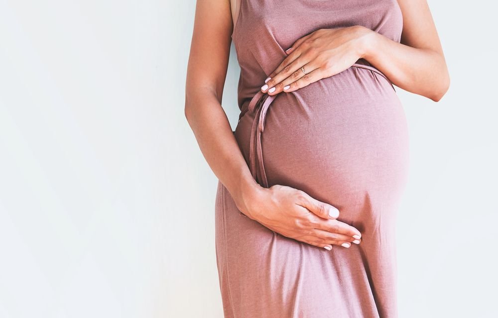 A woman holding her pregnant belly. | Source: Shutterstock
