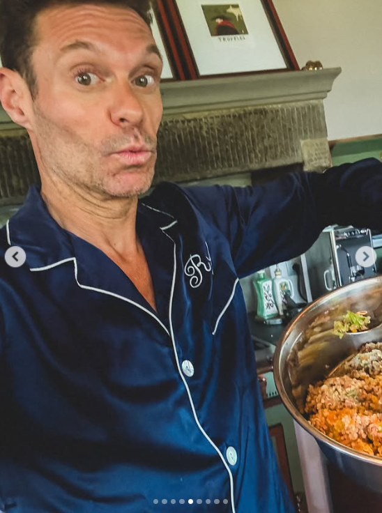 Ryan Seacrest poses in navy pajamas while holding a bowl of dog food, posted on June 30, 2025 | Source: Instagram/ryanseacrest