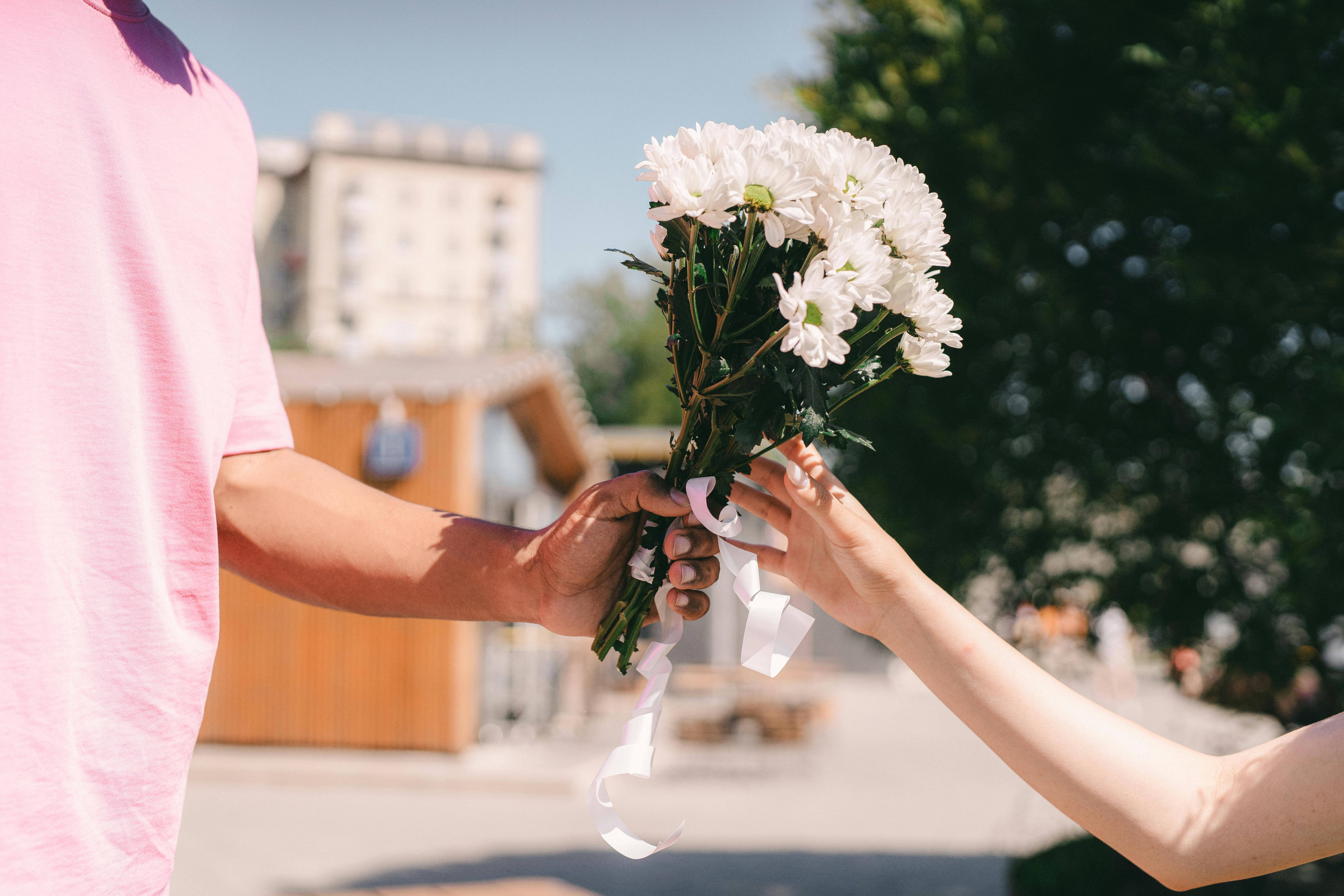 A person handing someone flowers | Source: Pexels