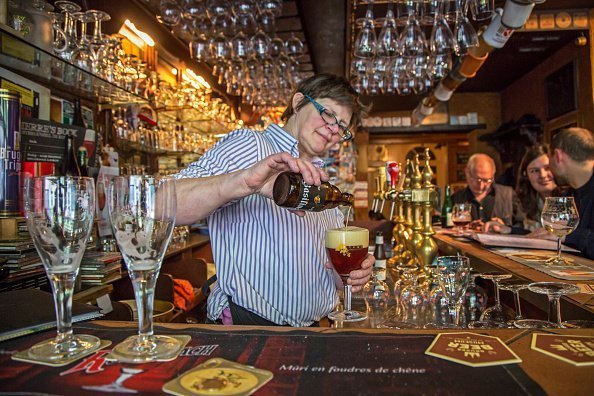 Bartender pouring Belgian beer in glass in the cafe Brugs Beertje | Photo: Getty Images