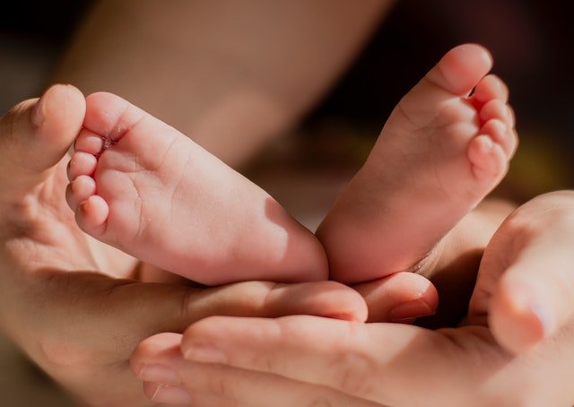 Persona sosteniendo los pies de un bebé. |Foto: Pexels / Laura Garcia 