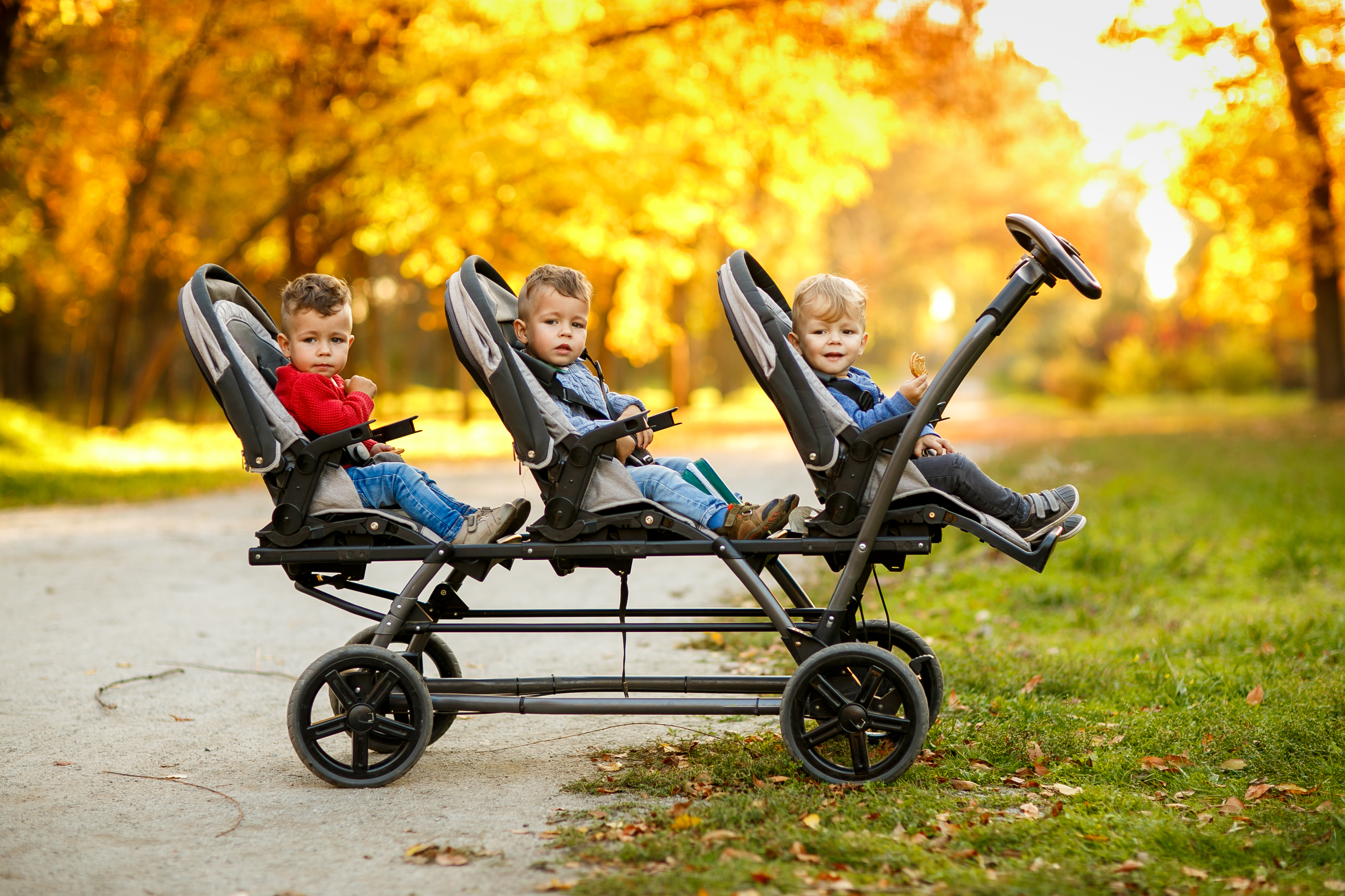 Cheerful triplets in a park. | Source: Shutterstock