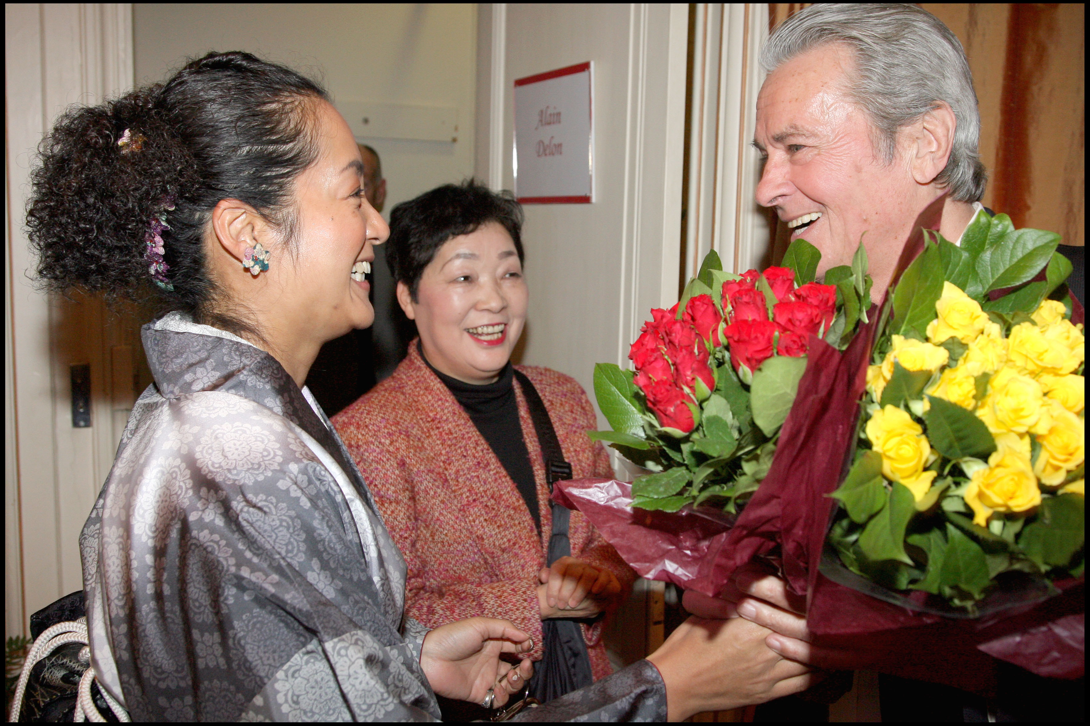 Alain Delon receiving flowers from fans who flew from Japan to see him in the theatre show 