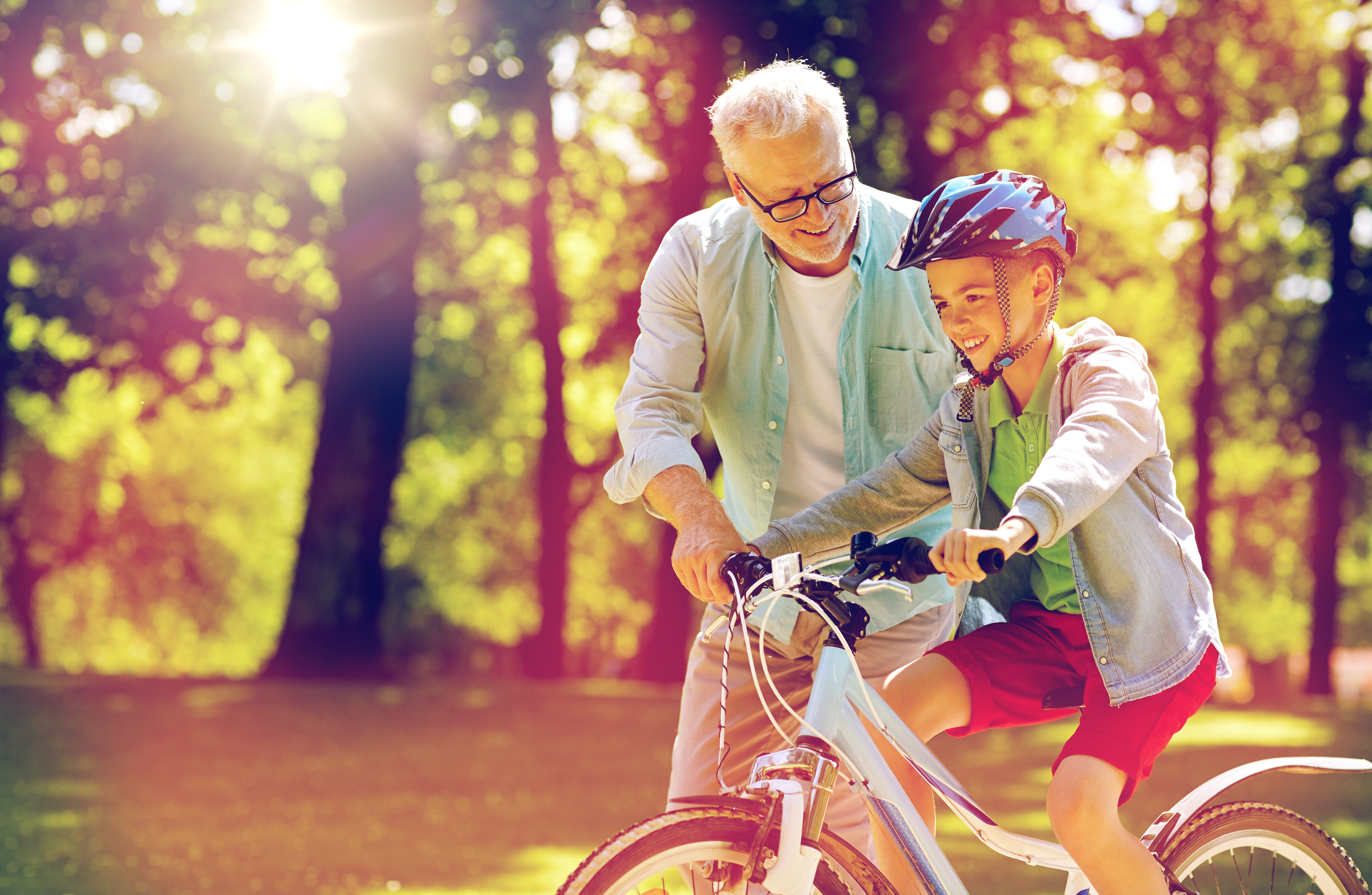 A grandfather teaching his grandson to ride a bicycle | Source: Shutterstock