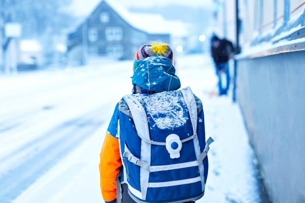 Boy walks along snowy streets | Photo: Shutterstock