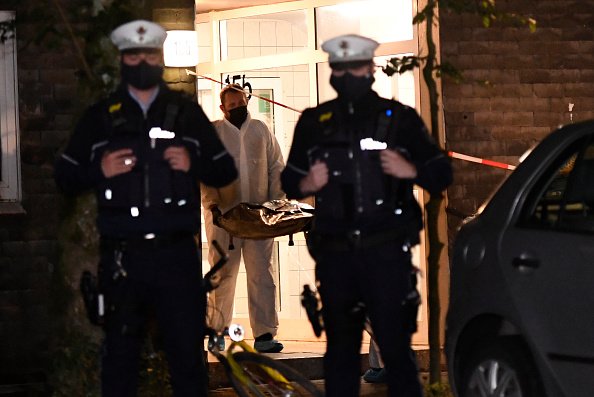 Polizisten bringen eine der Leichen aus dem Haus, September 2020, Solingen | Quelle: Getty Images