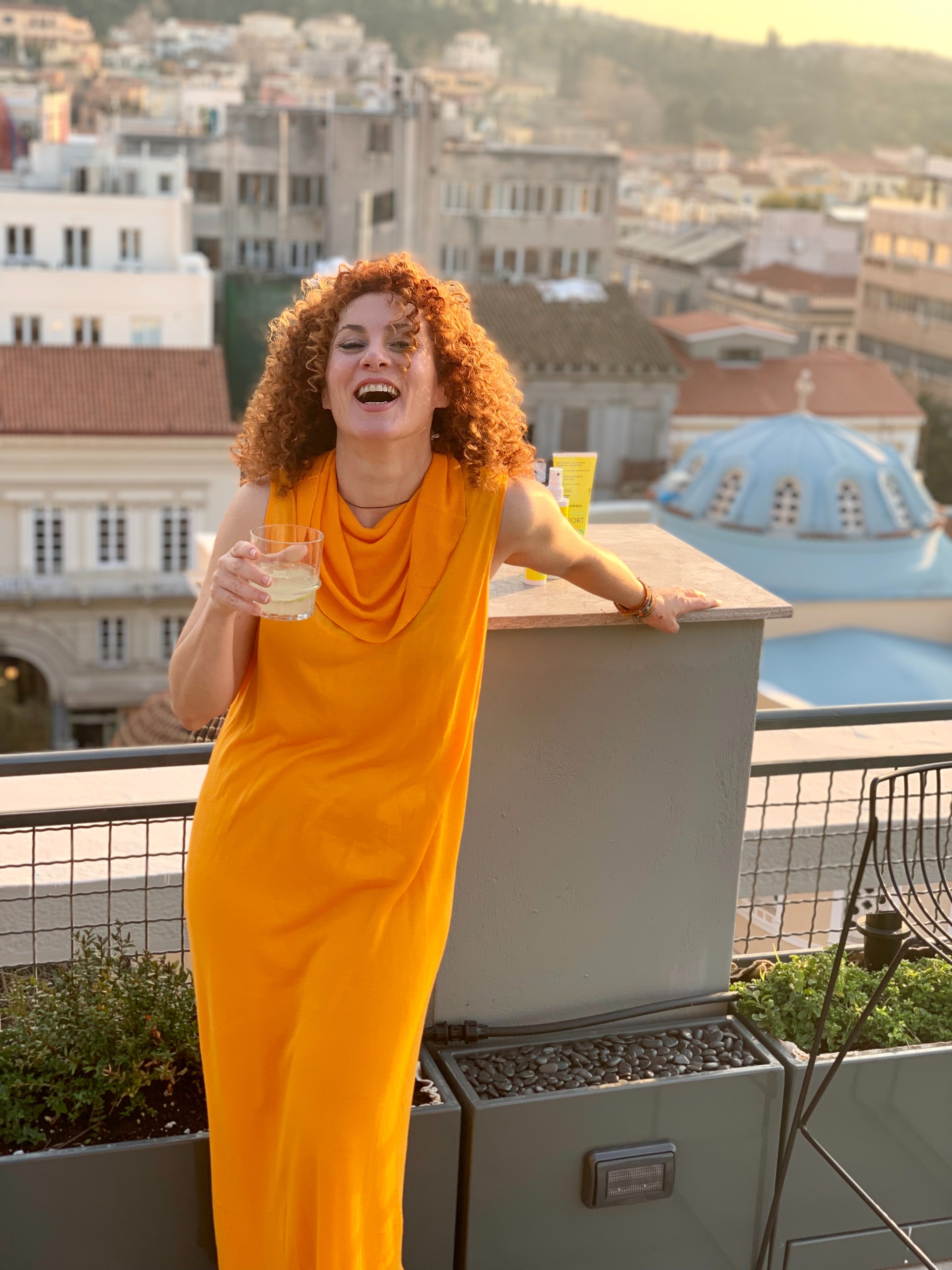 A happy woman poses on a balcony. | Source: Pexels