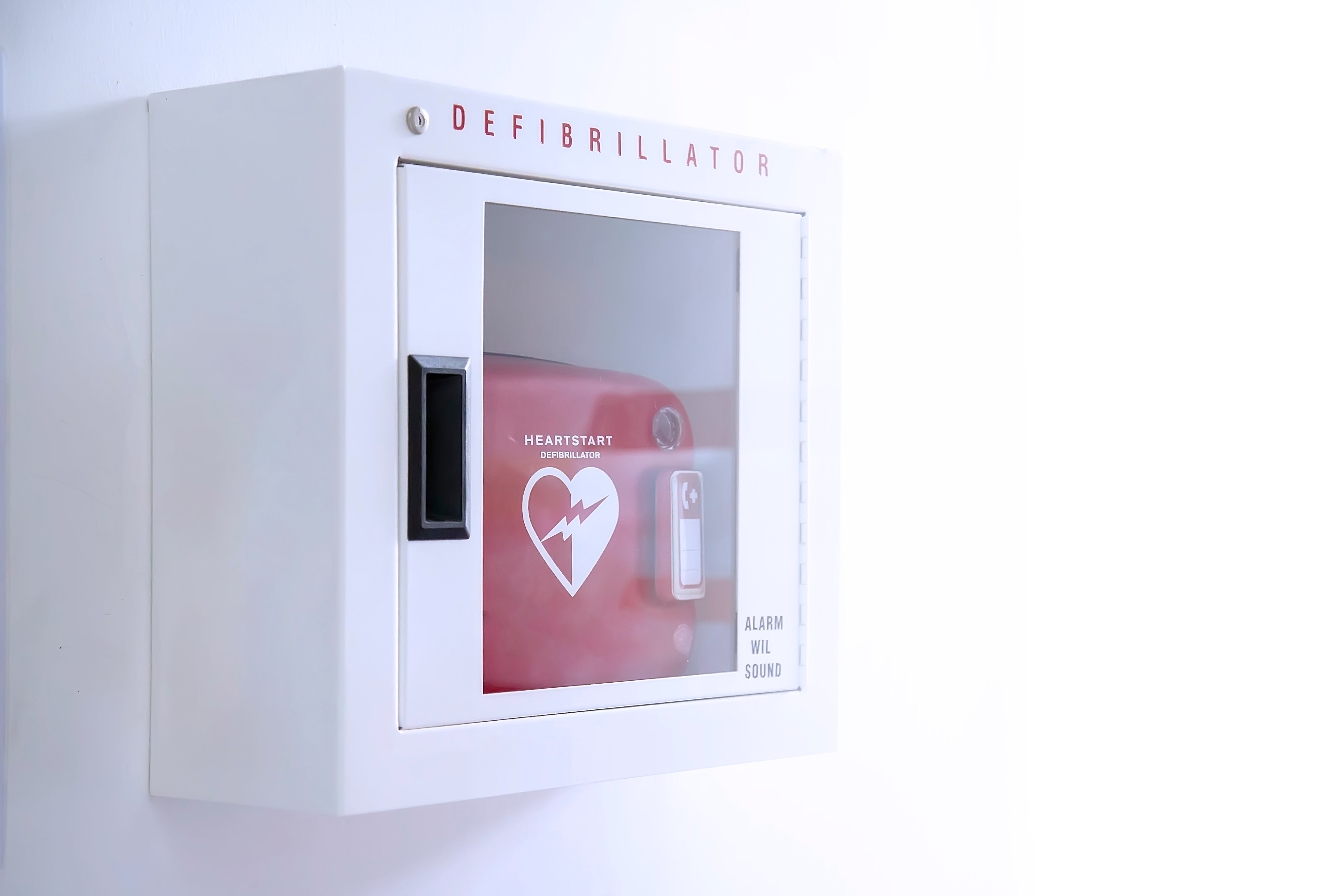 Automated External Defibrillator (AED) in weißer Schachtel an der Wand Ist ein Notfall-Schrittmacher Gerät für Menschen mit Herzstillstand. Herzdefibrillator auf weißem Hintergrund. | Foto von: Witsawat.S via Shutterstock 
