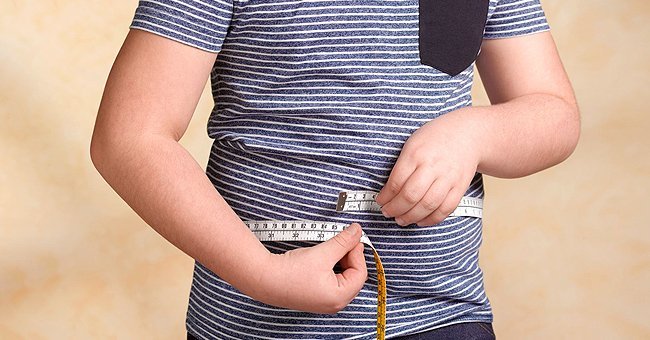 Junge misst seine Taille | Quelle: Getty Images
