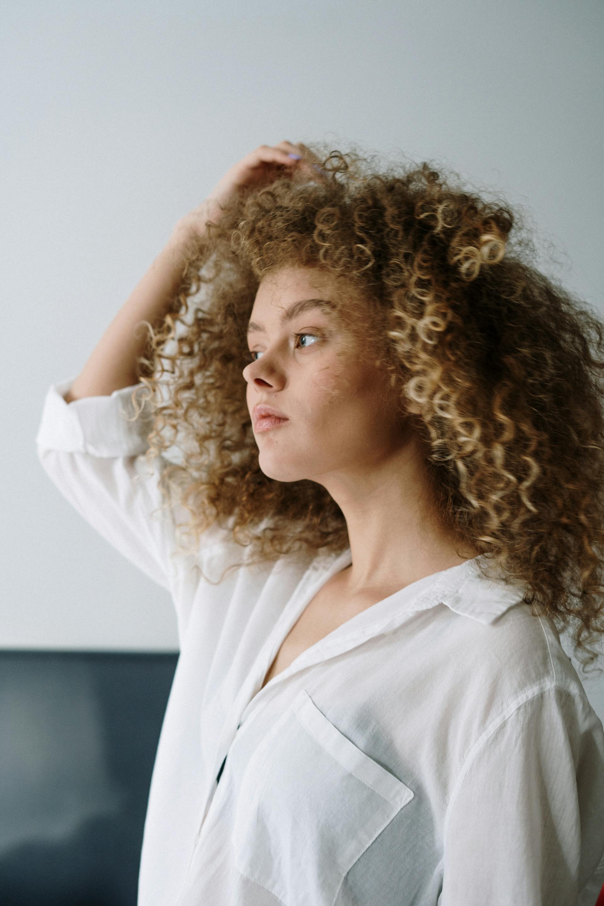 A woman putting a hand to her head | Source: Pexels