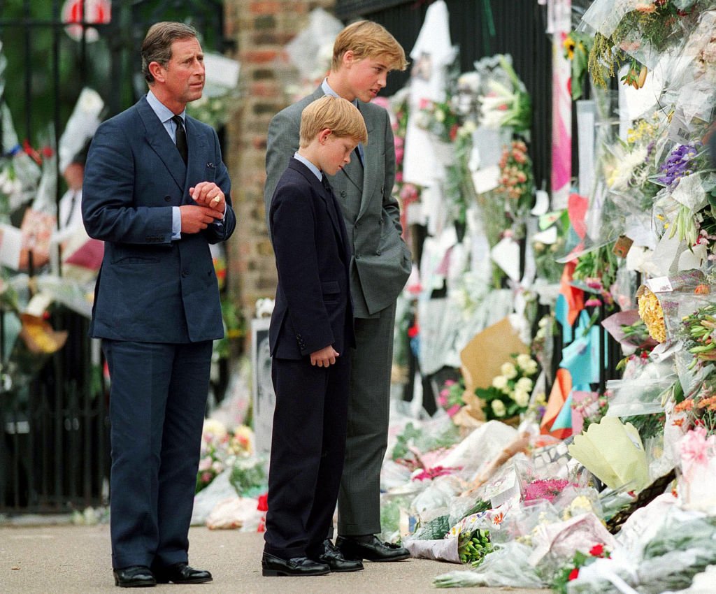 Prinz Charles, Prinz William und Prinz Harry sehen am 5. September 1997 in London, England, vor dem Kensington Palace florale Hommagen an Diana. | Quelle: Getty Images