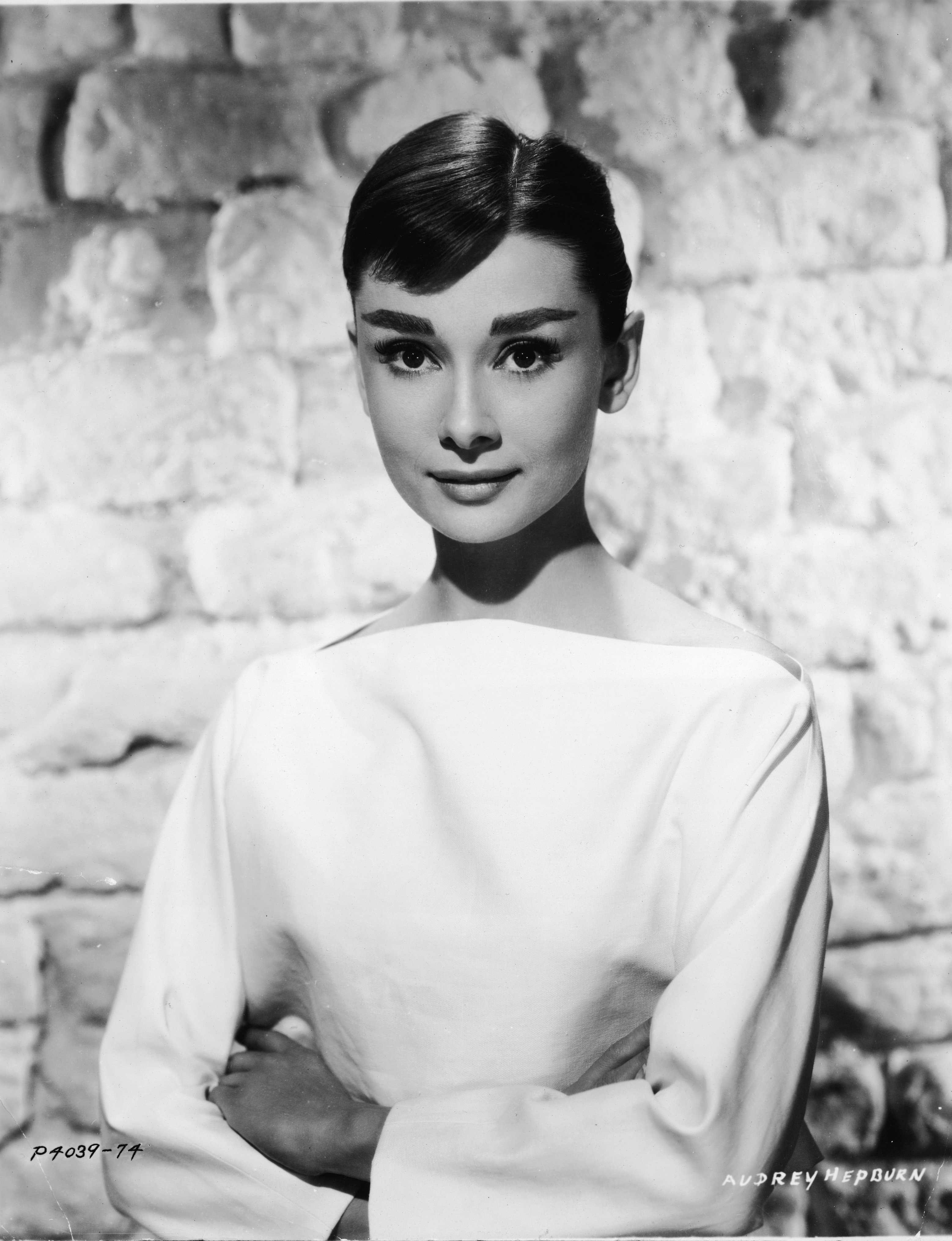 American actress Audrey Hepburn circa 1955 in a white long-sleeved dress. | Getty Images
