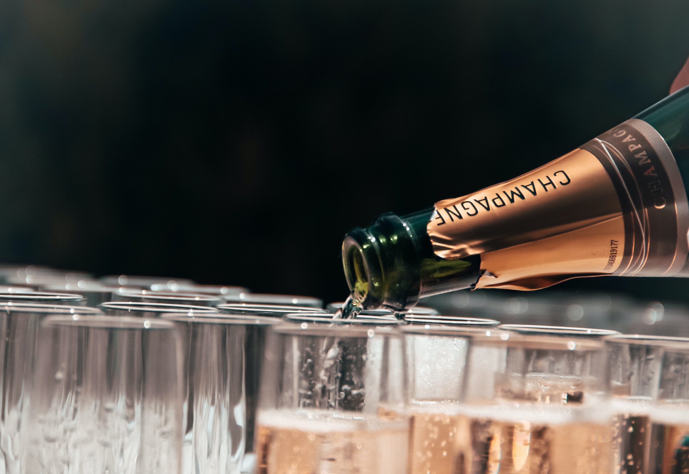 Glasses on champagne being filled with the beverage | Source: Unsplash