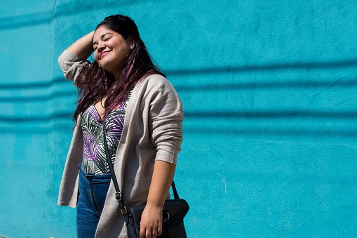 Portrait d'une femme debout devant un mur bleu. | Photo : Getty Images