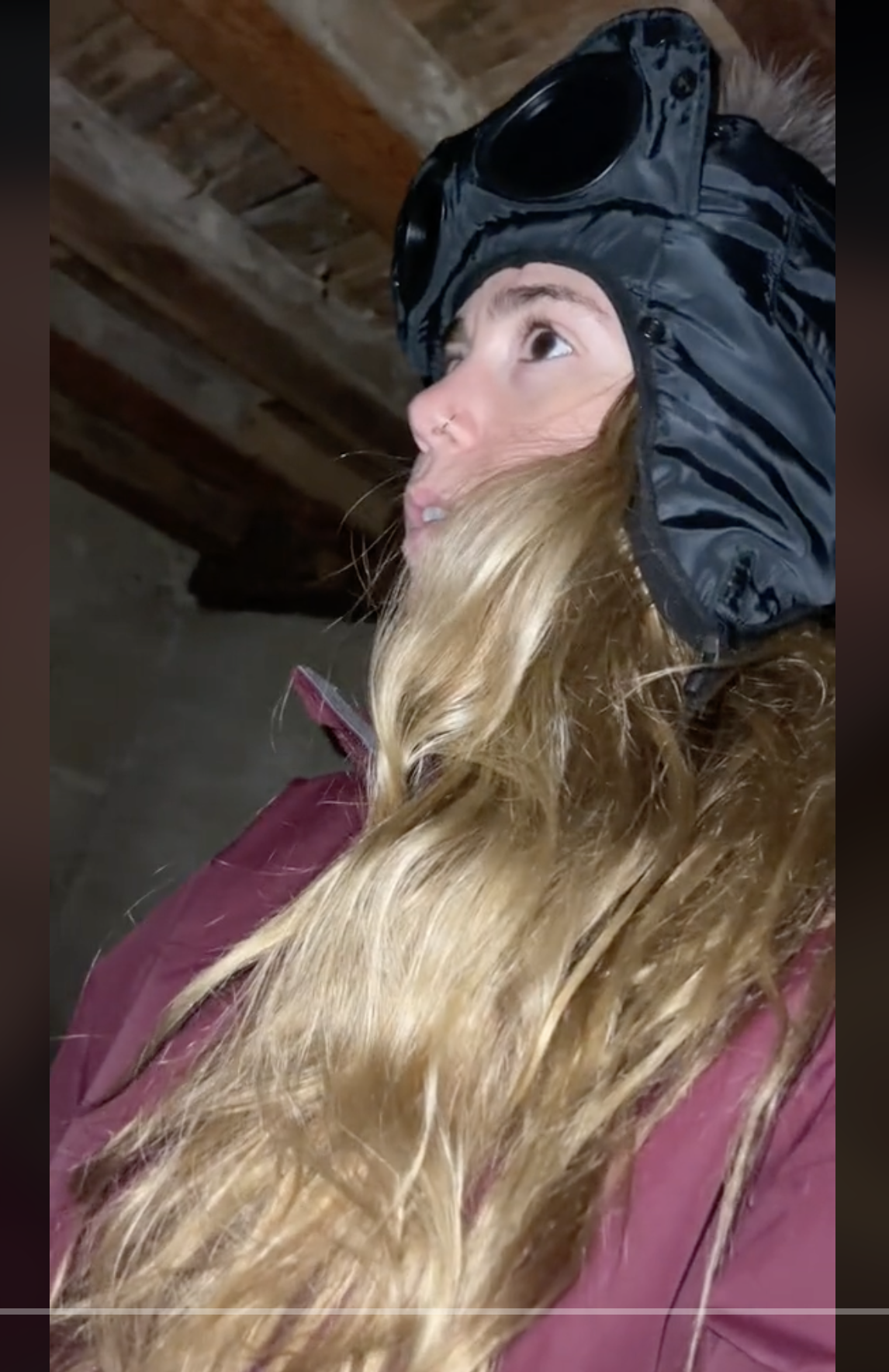 Julia Henning wearing a coat and ski mask while discovering the mysteries inside her home in a video dated June 16, 2023 | Source: tiktok.com/@iamjuliahenning