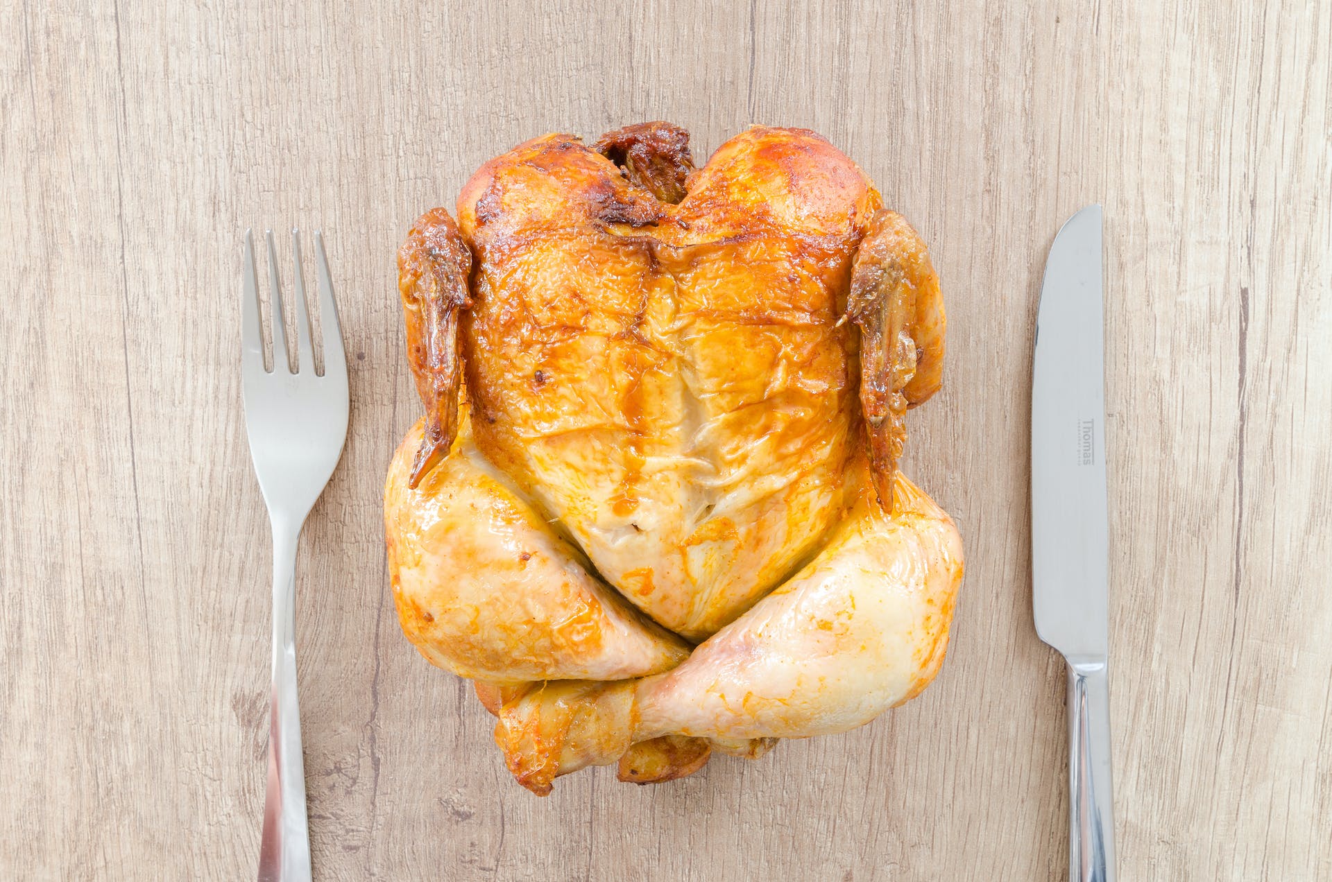 Roasted chicken on a wooden surface | Source: Pexels