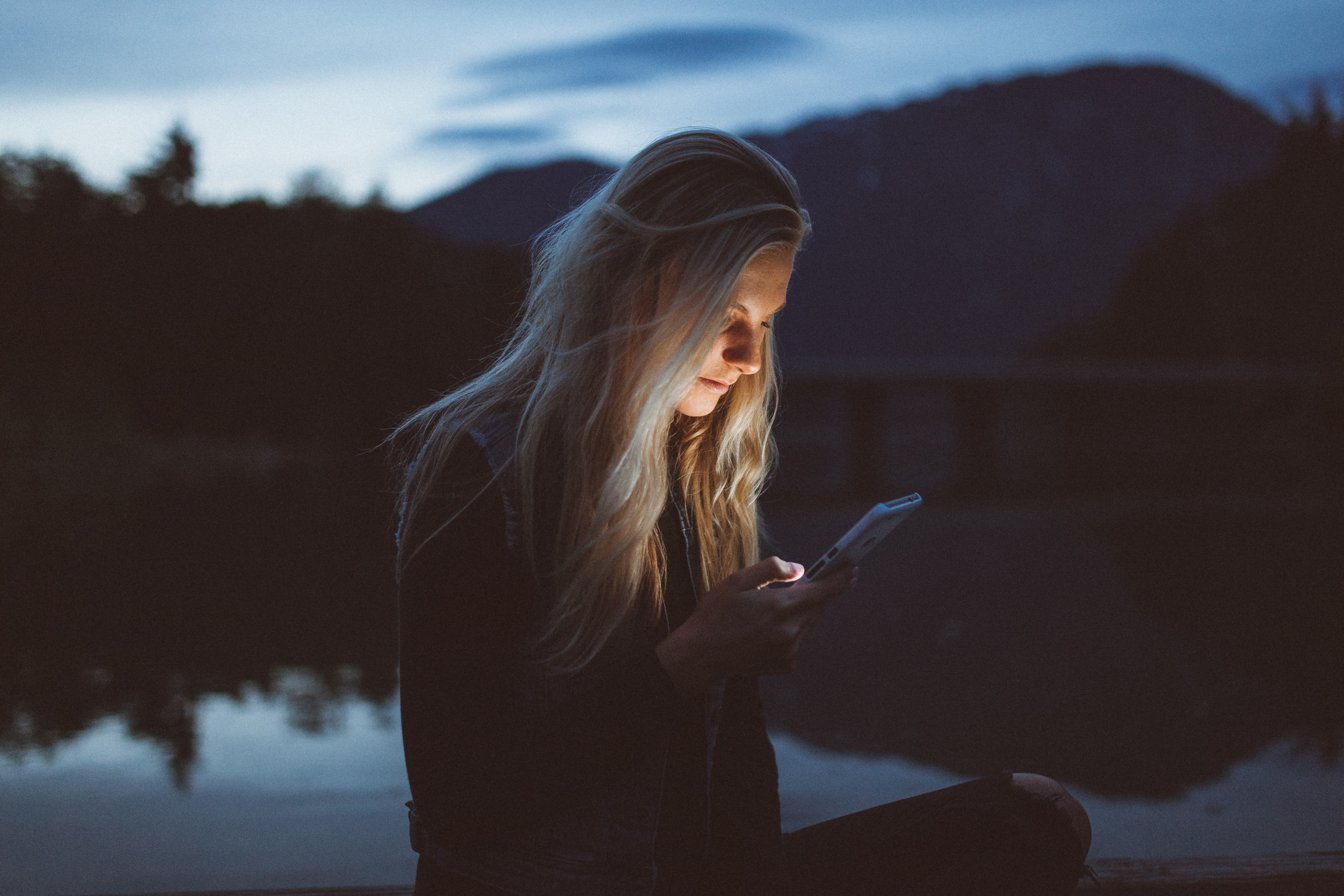 Young woman staring at her phone | Photo: Unsplash