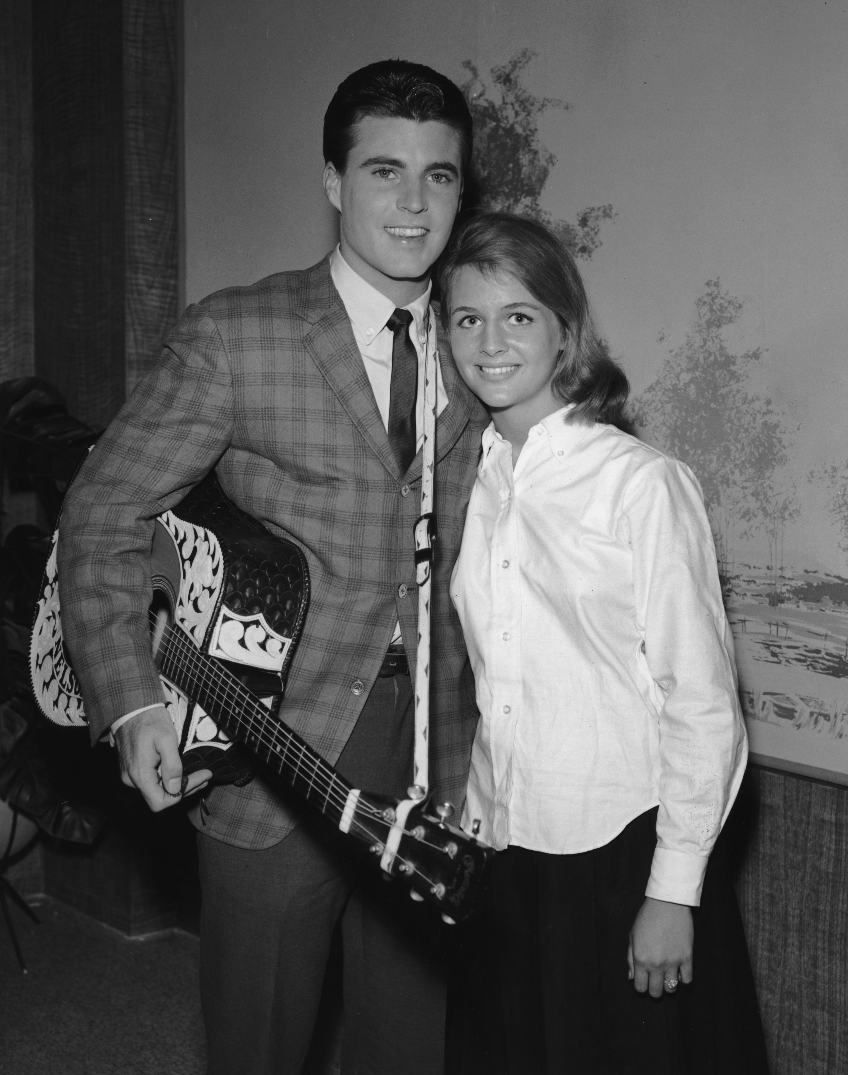 Rick Nelson smiles with his wife Kristin Harmon. He holds an acoustic guitar. Circa 1963 | Source: Getty Images