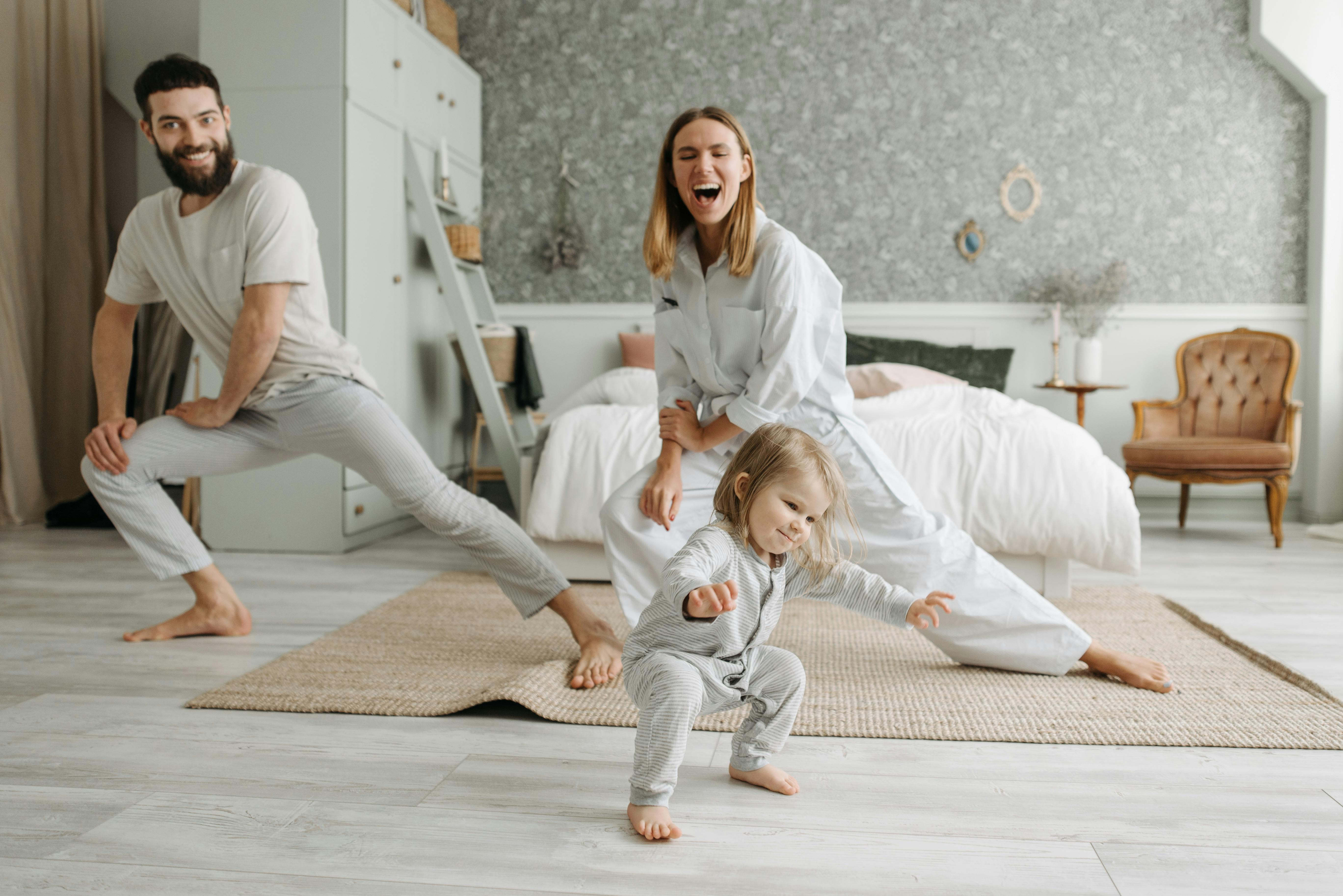 A mom, dad, and their small daughter doing stretches | Source: Pexels