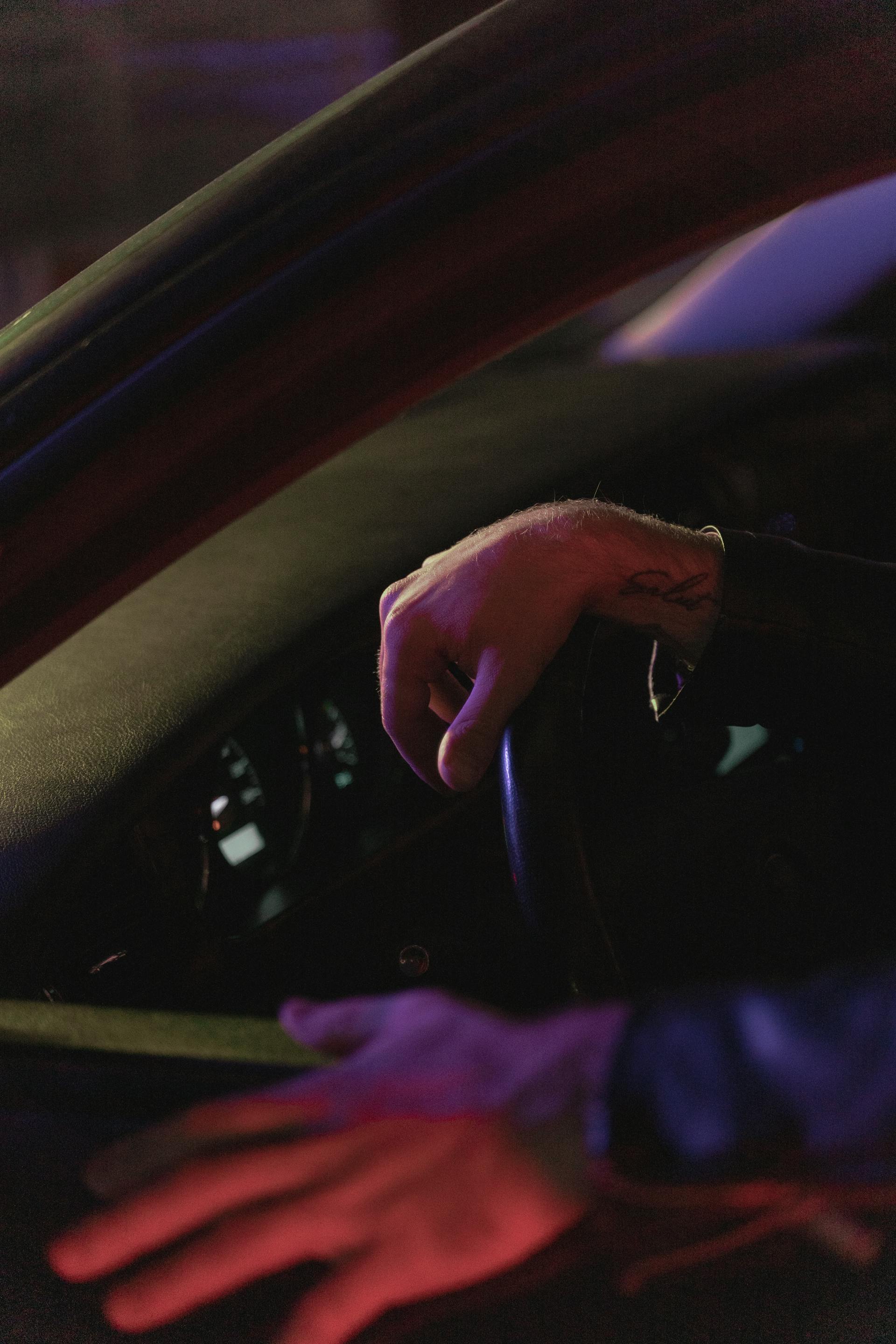 A man's hand on the steering wheel of a car | Source: Pexels